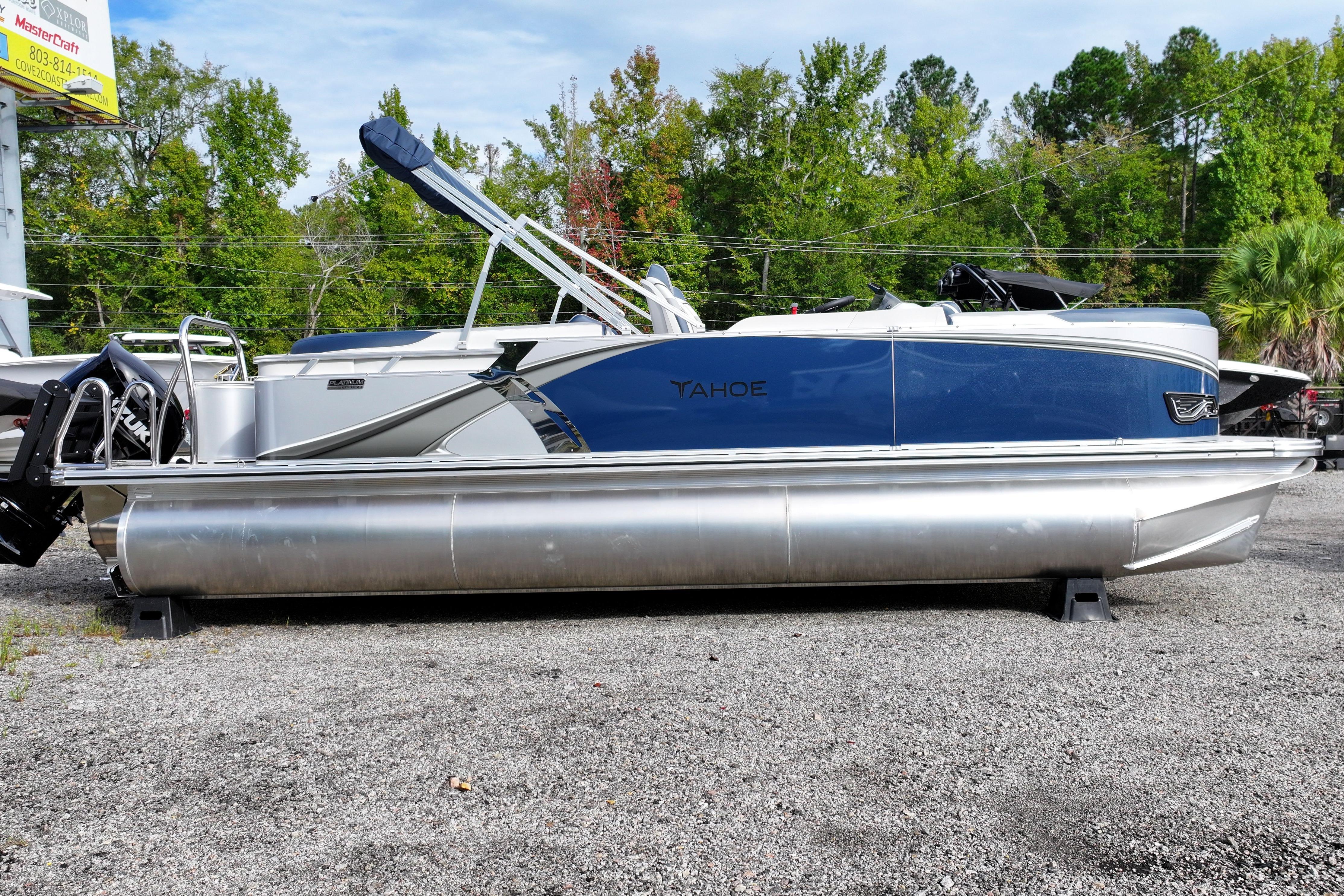 2026 Tahoe Pontoon LTZ Quad Lounger, blue and silver, parked outdoors on gravel.