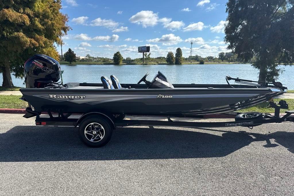 2026 Ranger RT188 boat parked by a scenic lake under a clear blue sky.