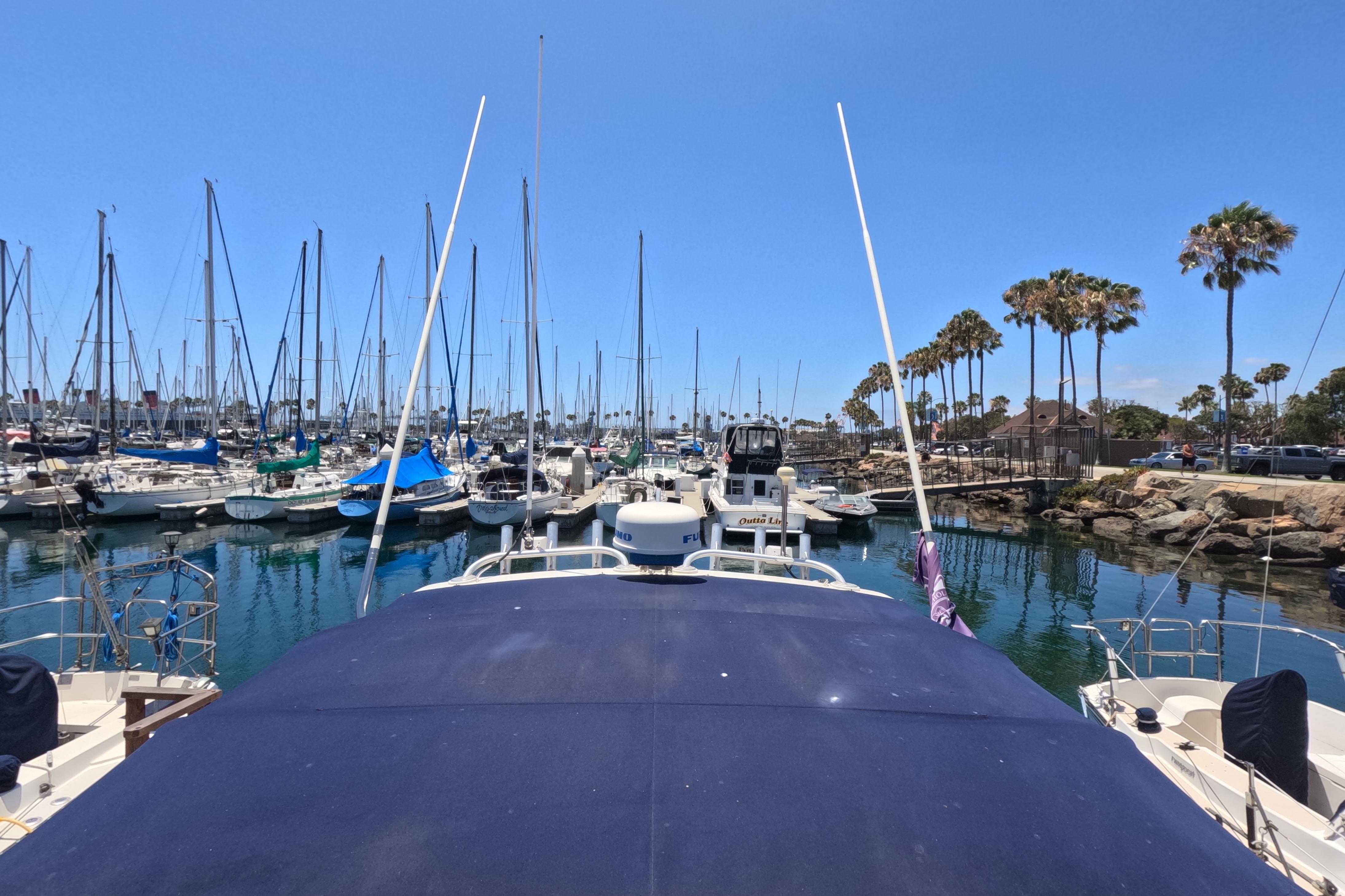 Tiara Yachts 2900 Open 1995 docked in a marina with sailboats and palm trees.
