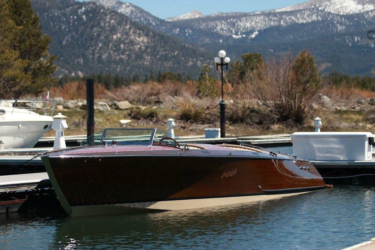 2007 Hacker-Craft 32 Sportabout boat docked with mountain backdrop.