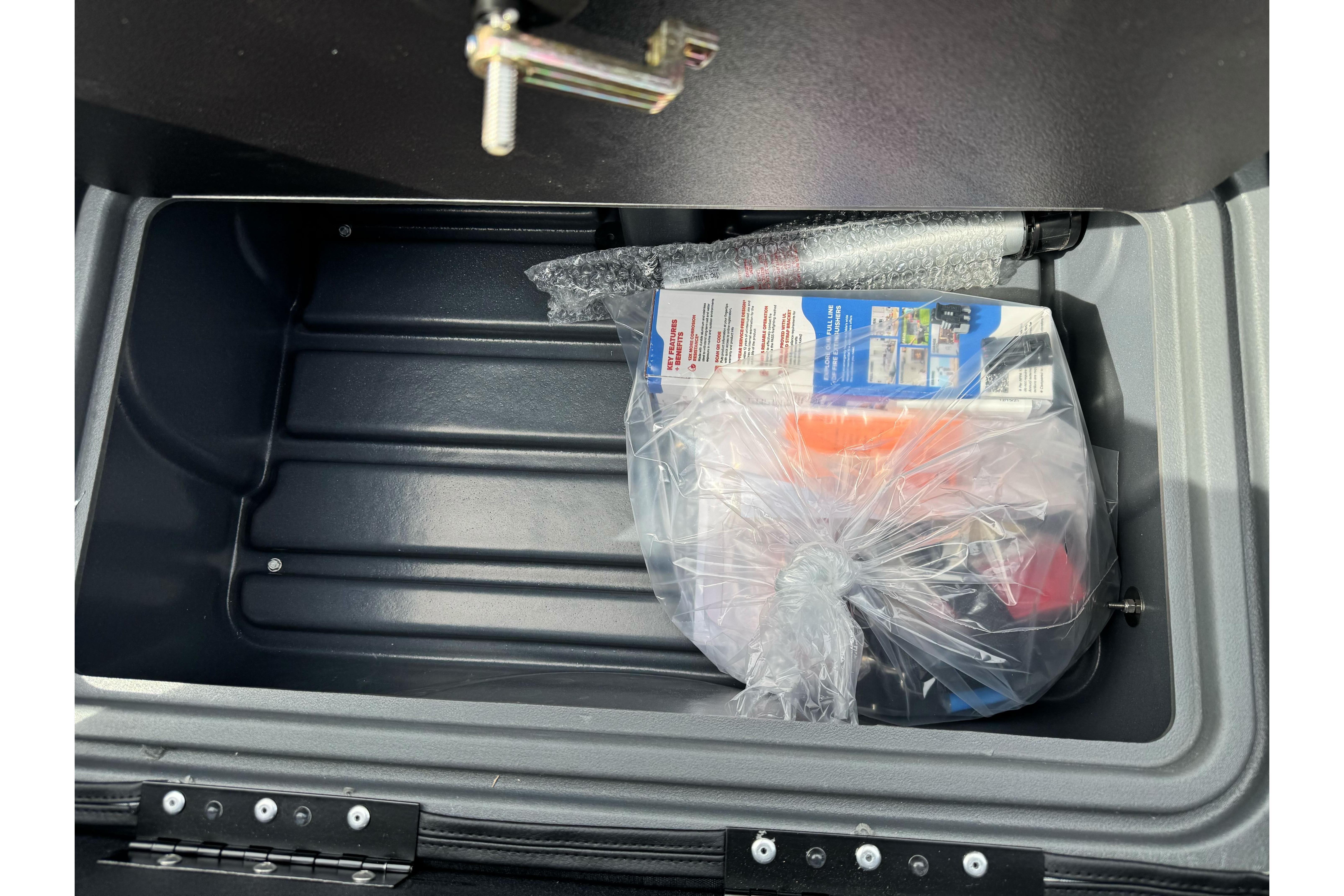 Open storage compartment of 2026 Regency 250 DL with packaged items inside.