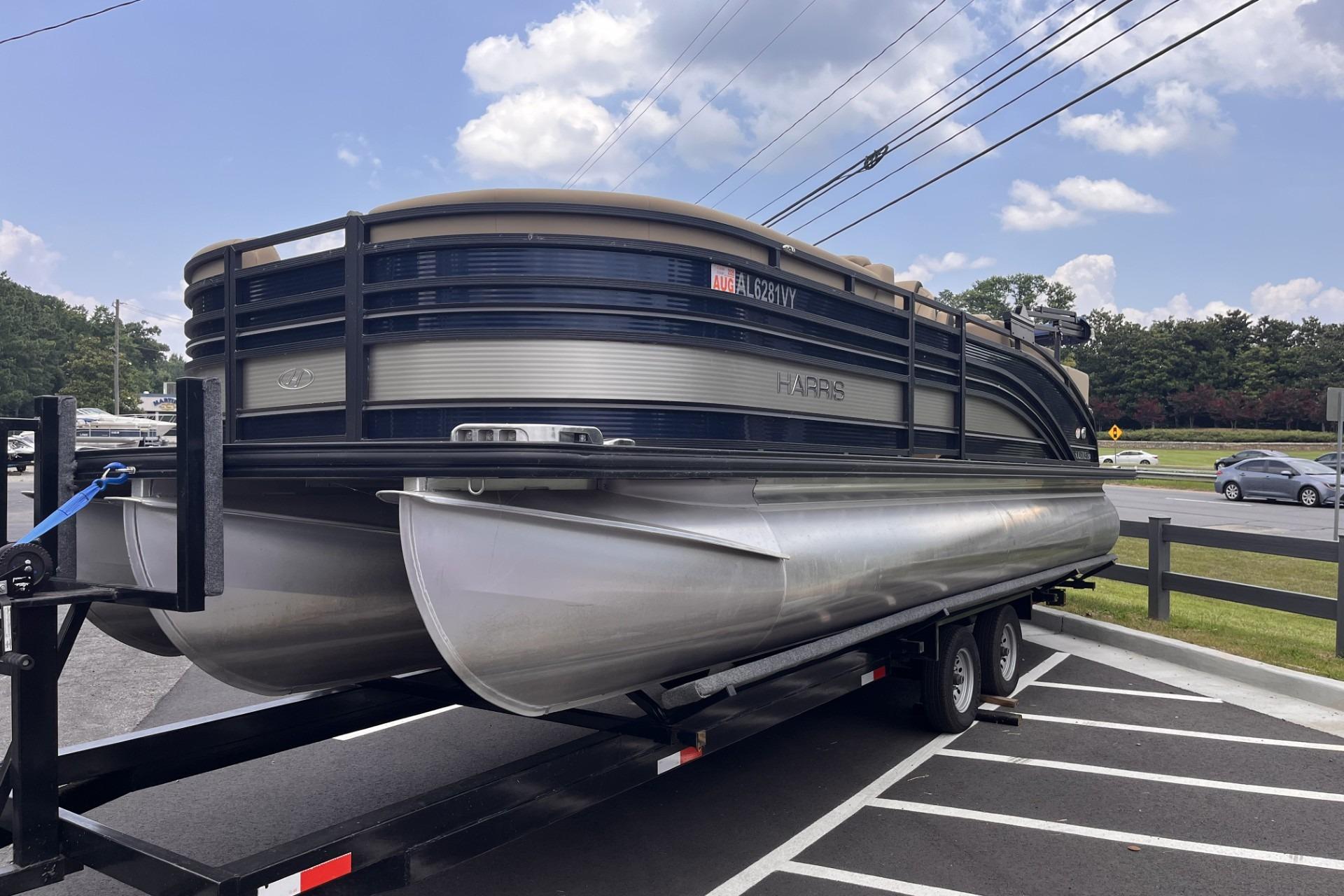 2022 Harris Solstice 230 CWDH pontoon boat on trailer in parking lot.