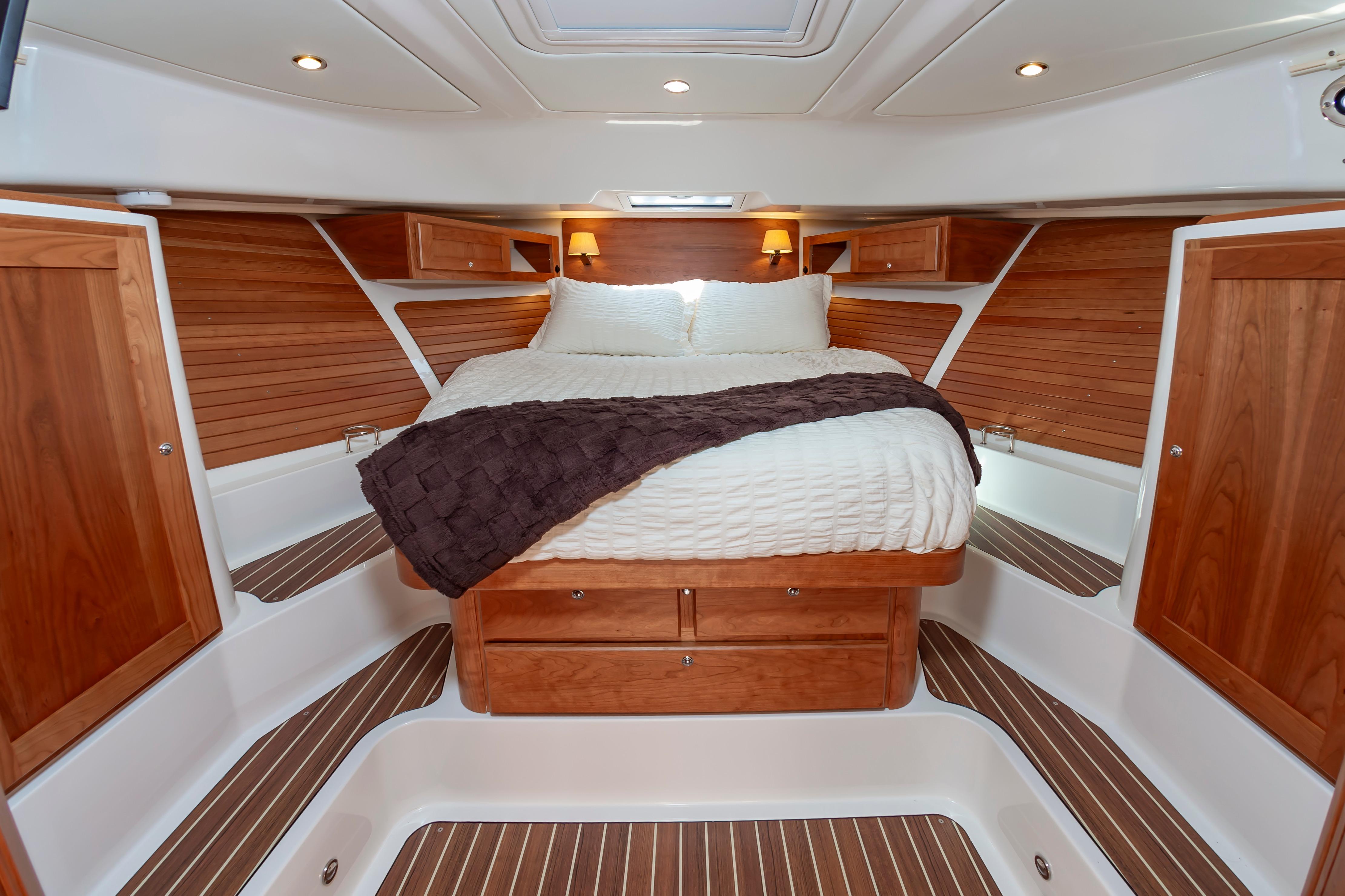 Luxurious cabin interior of 2025 Back Cove 39O yacht with wood accents and cozy bedding.