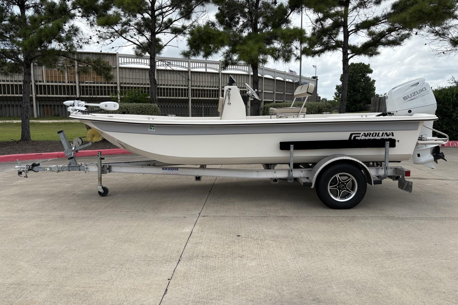 2024 Carolina Skiff E18 JVX CC boat on trailer, parked outdoors.