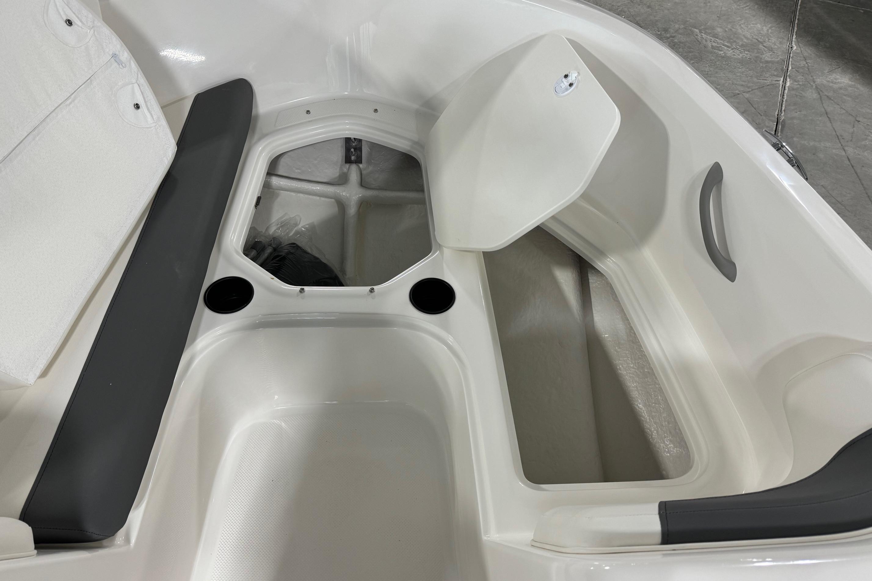 2025 Bayliner Element E18 boat interior storage compartment with seating and cup holders.