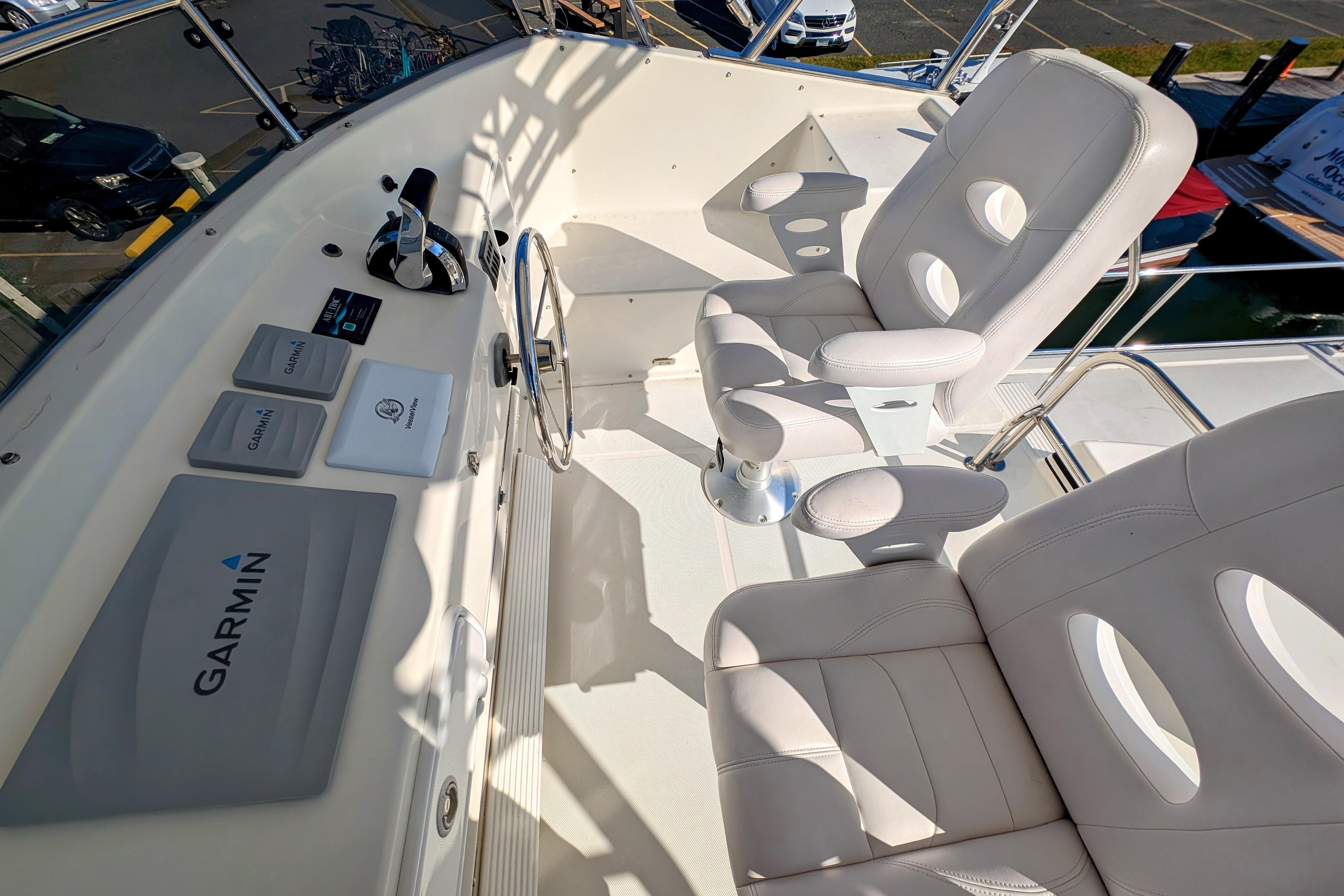 American Tug 435 helm with Garmin navigation, featuring plush white seating, 2015 model.