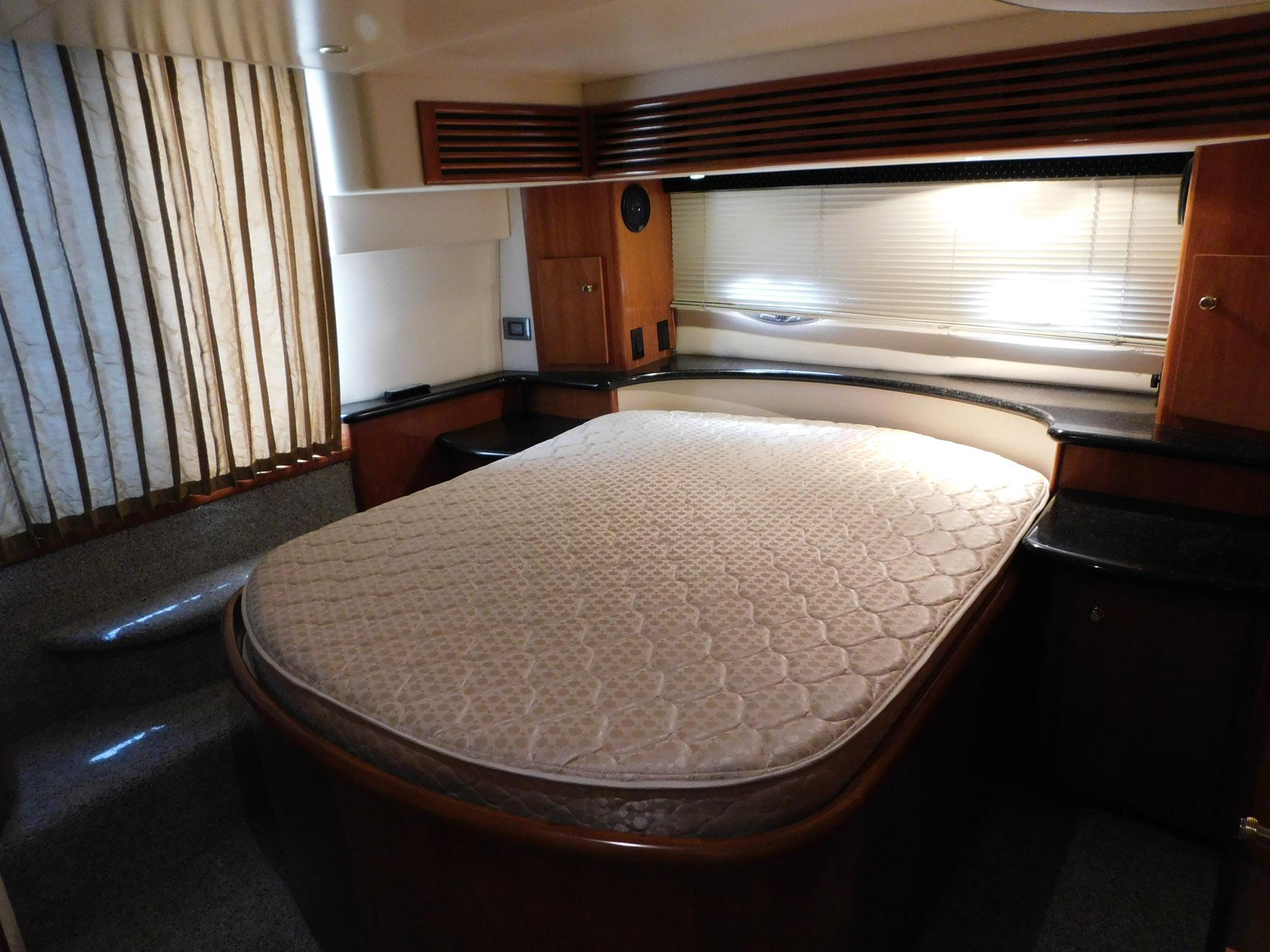 Luxurious bedroom interior of 2003 Carver 444 Cockpit Motor Yacht with elegant wood finishes.