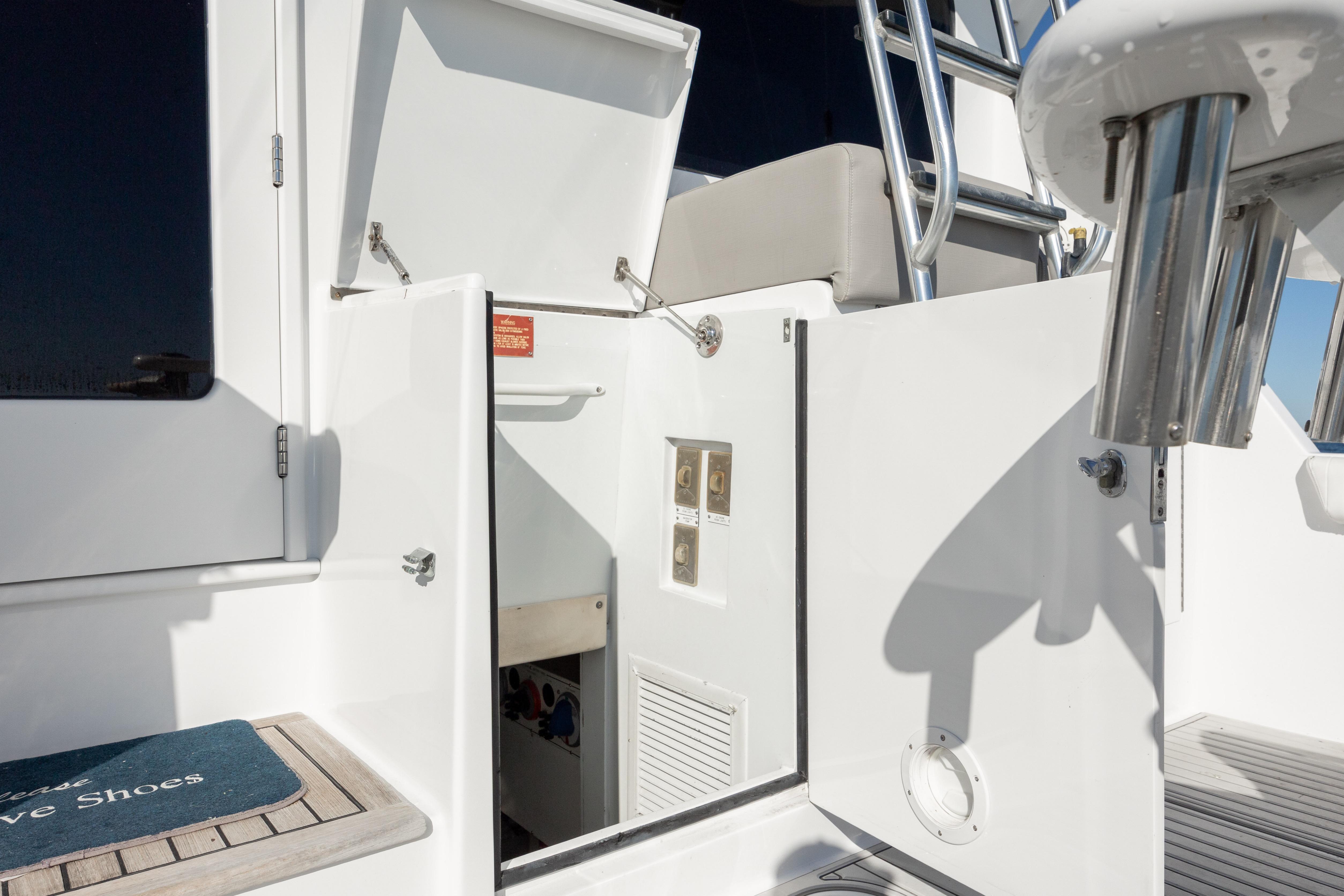 2000 Hatteras 50 Convertible yacht, open storage compartment, stainless steel ladder, and deck details.