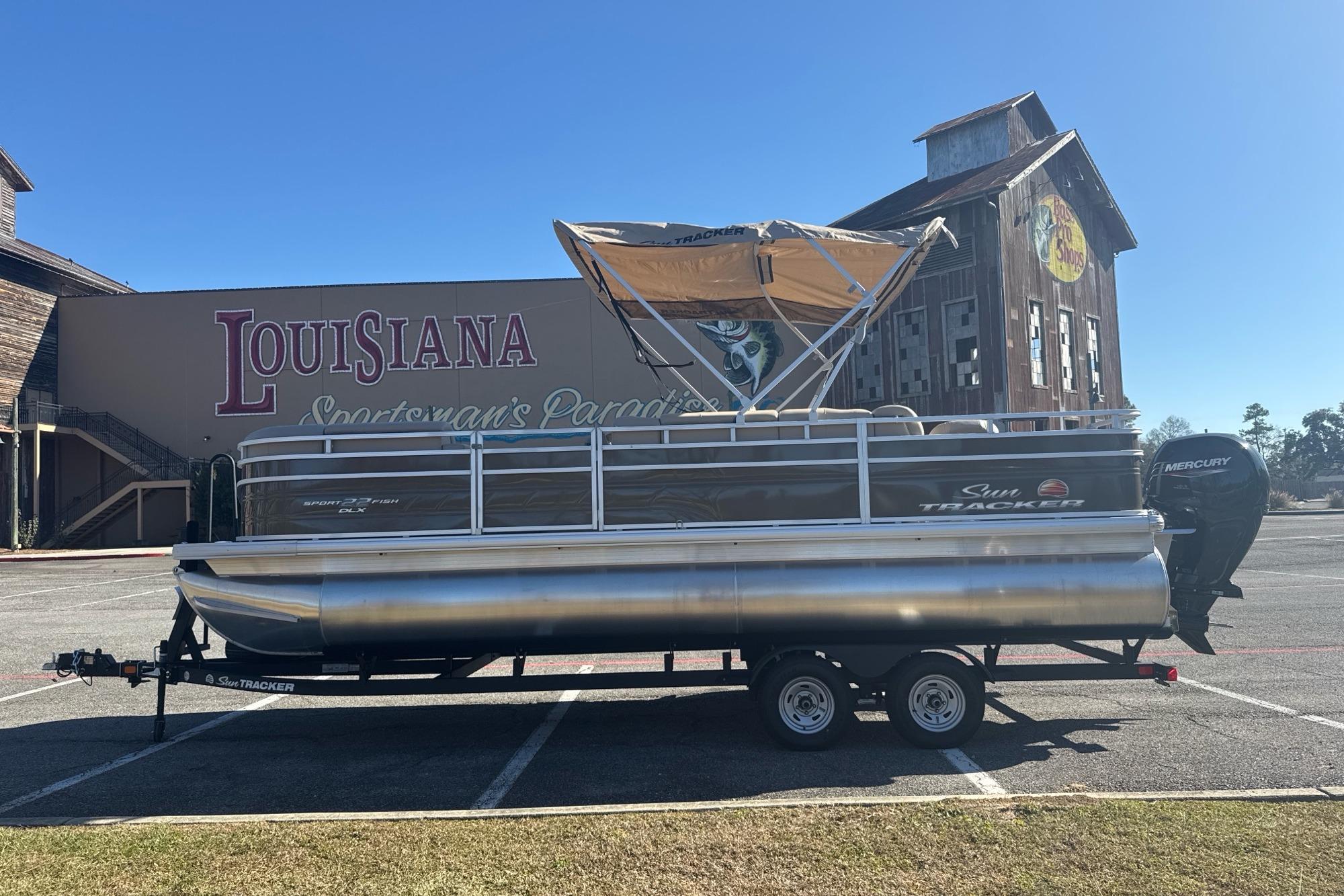 2025 Sun Tracker SportFish 22 DLX pontoon boat parked in Louisiana.