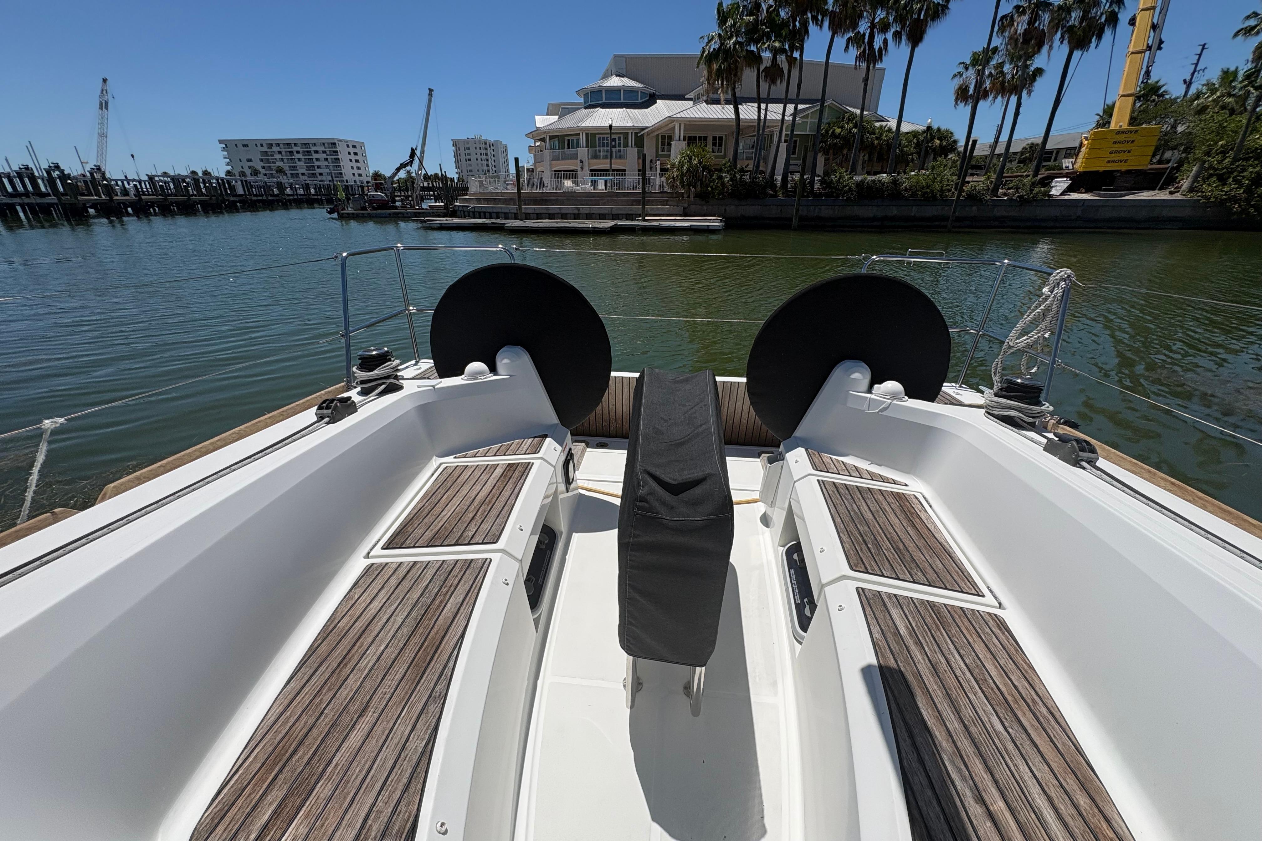2021 Jeanneau Sun Odyssey 349 sailboat cockpit with wooden seating, docked in a marina.