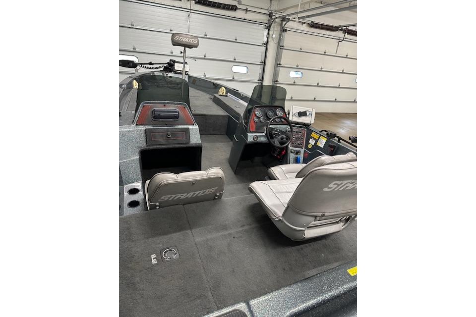 1999 Stratos 219 CF boat interior with steering console and seating in a garage.