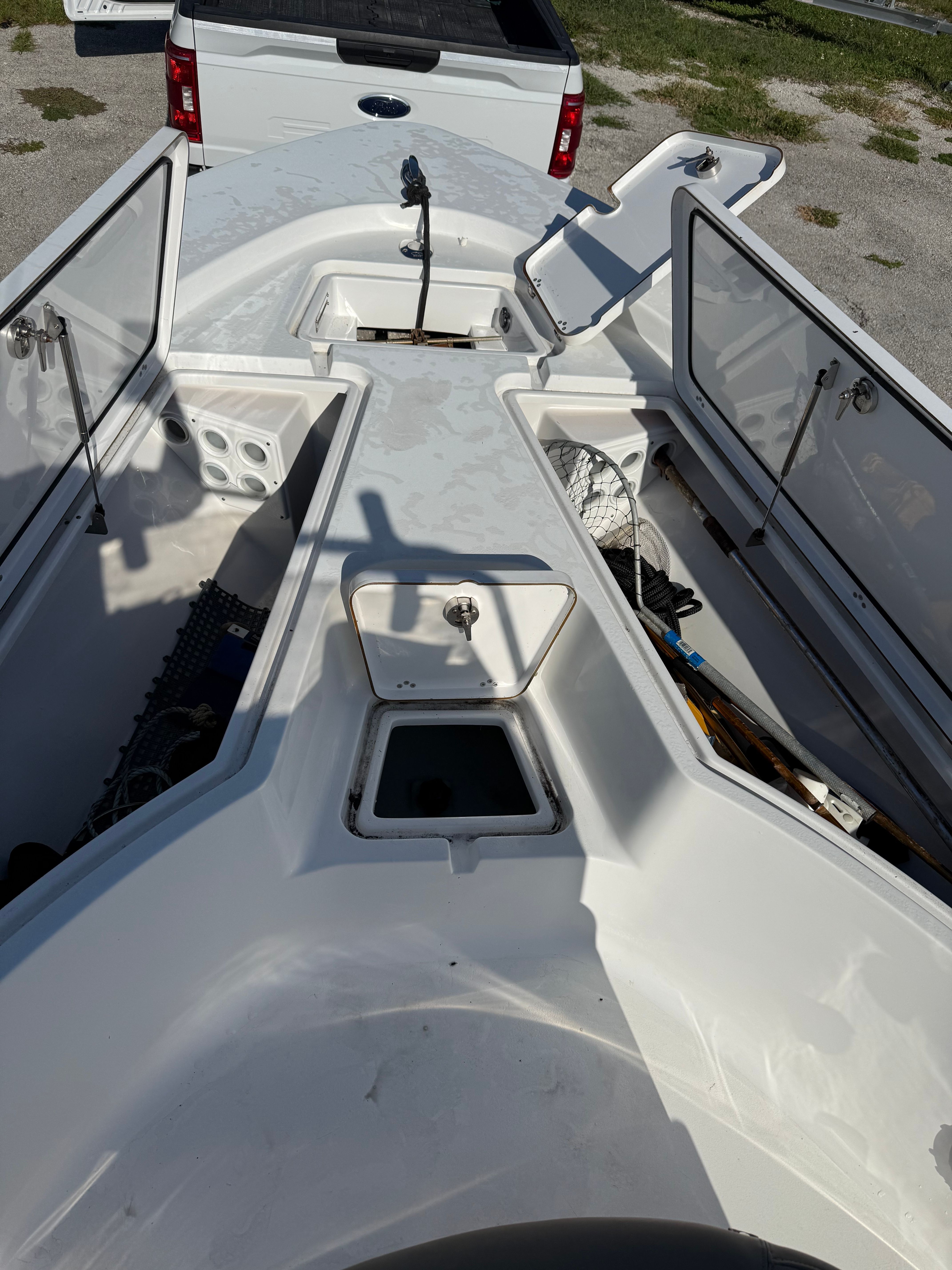 The image shows the deck of a Sportsman Masters 227 Bay Boat with open storage compartments.