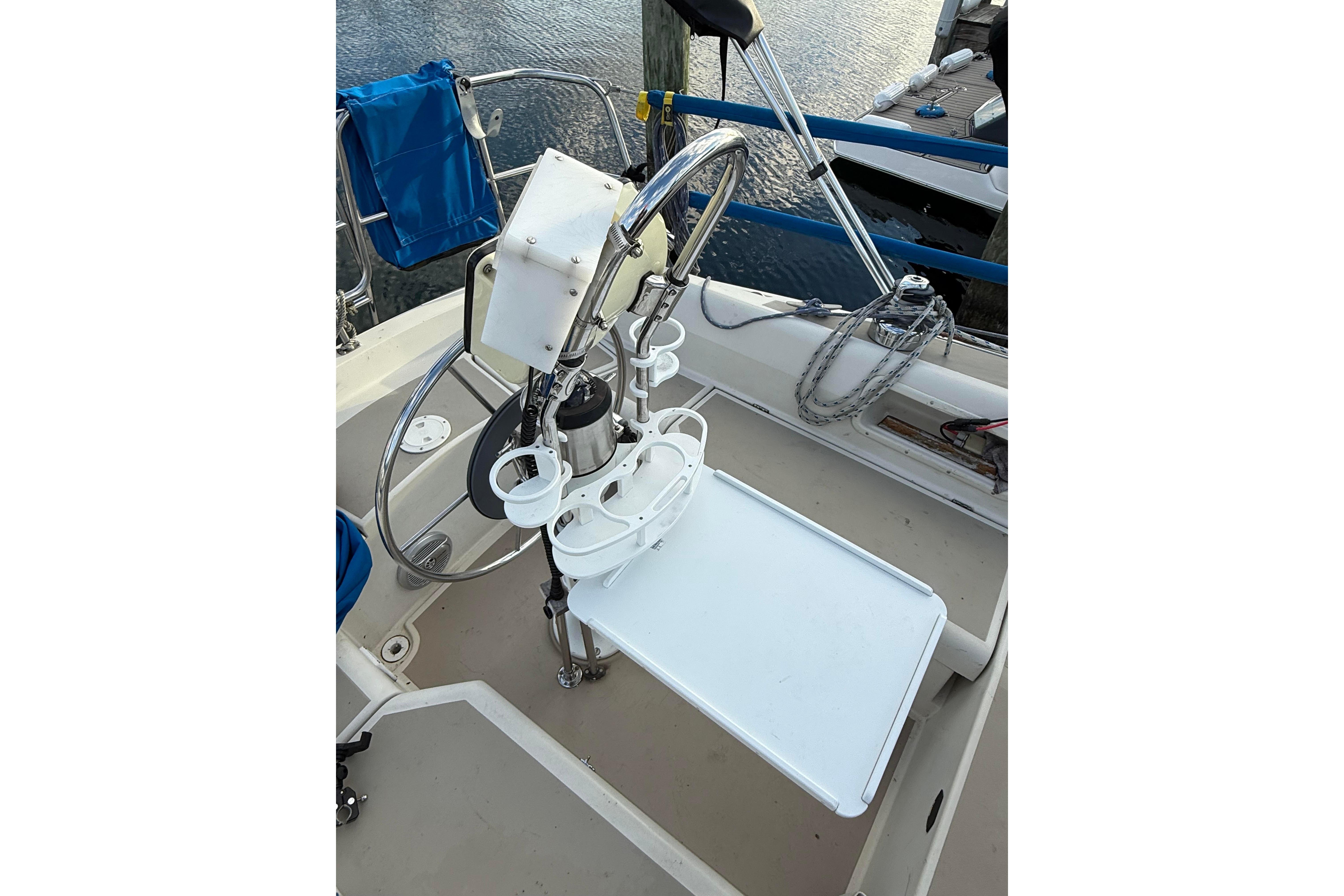 Cockpit of a 1983 O'Day 34 sailboat with steering wheel and accessories.