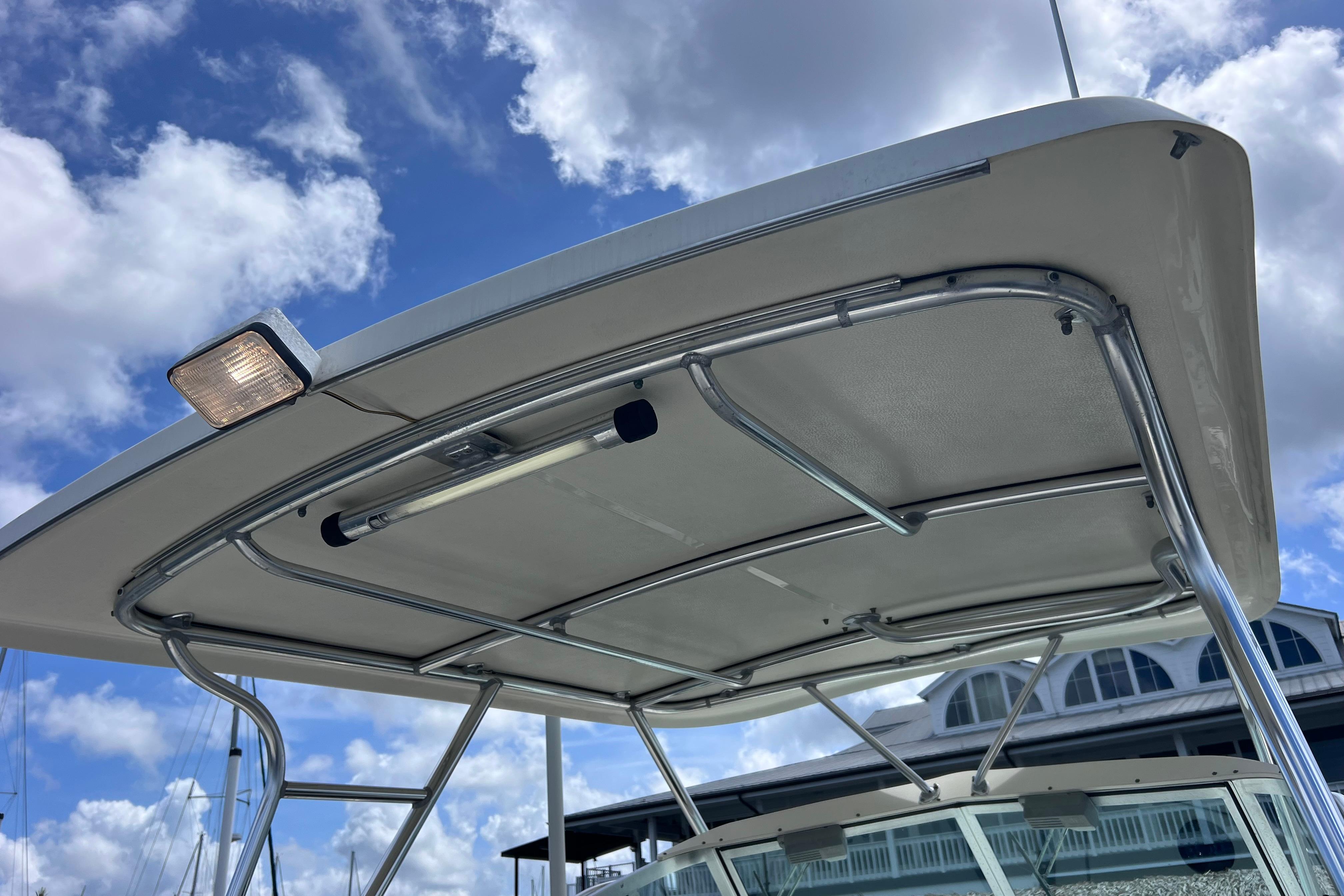 2004 Pursuit 2870 Walkaround boat canopy under blue sky with clouds.
