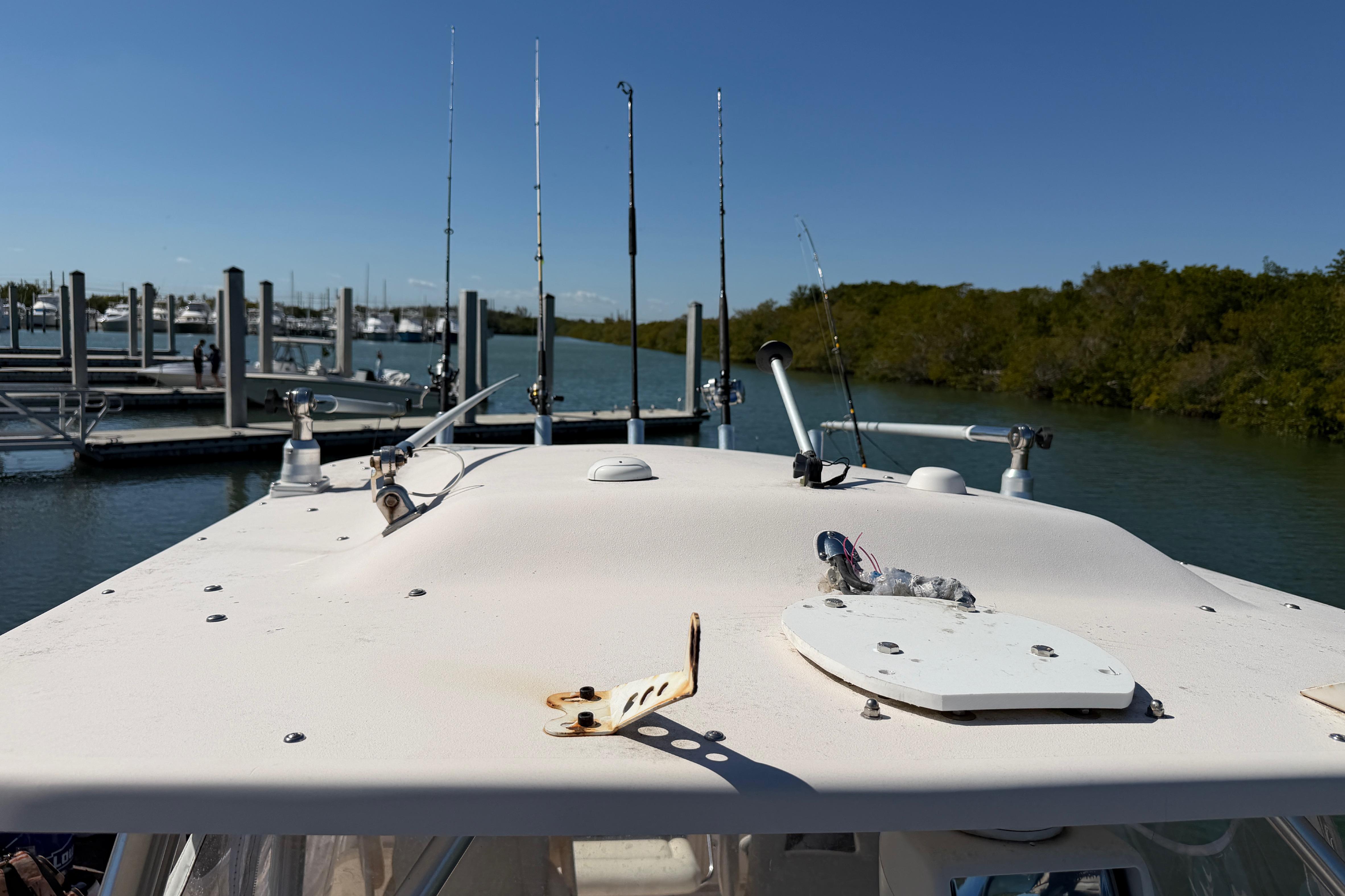 2006 Grady-White Sailfish 282 boat docked, featuring fishing rods and a clear blue sky.