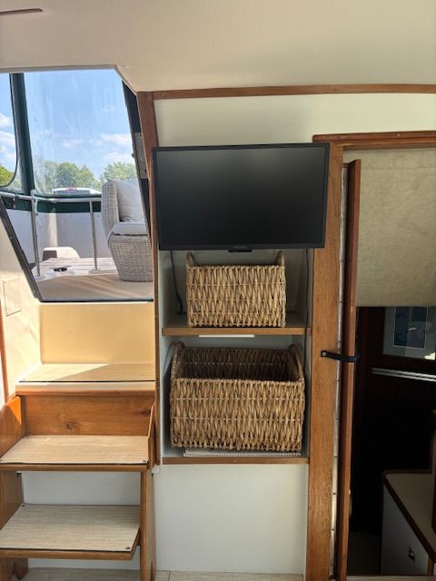 Interior of 1986 Sea Ray 360 Aft Cabin with TV and baskets.