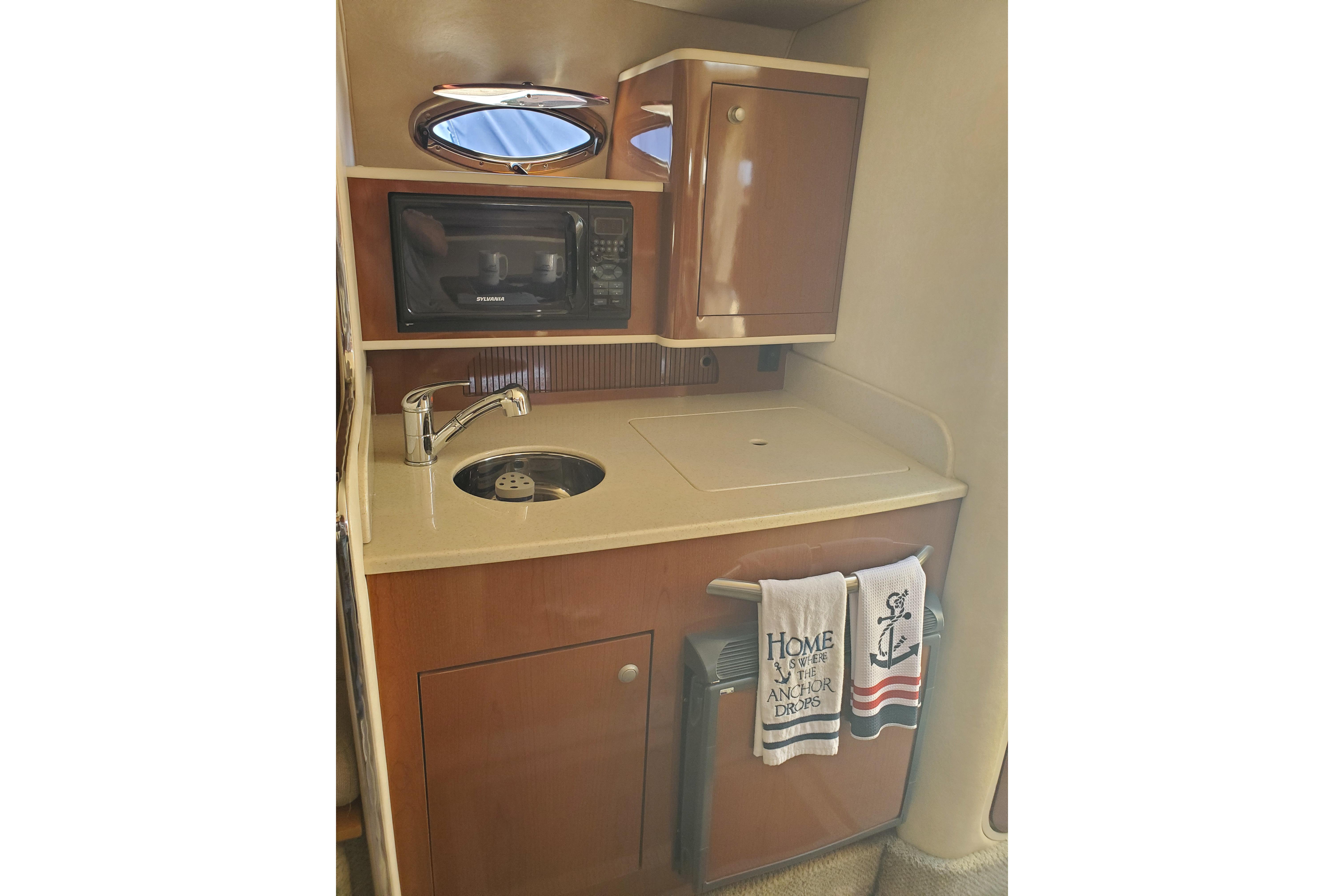 2008 Sea Ray Sundancer 280 galley with sink, microwave, and storage cabinet.