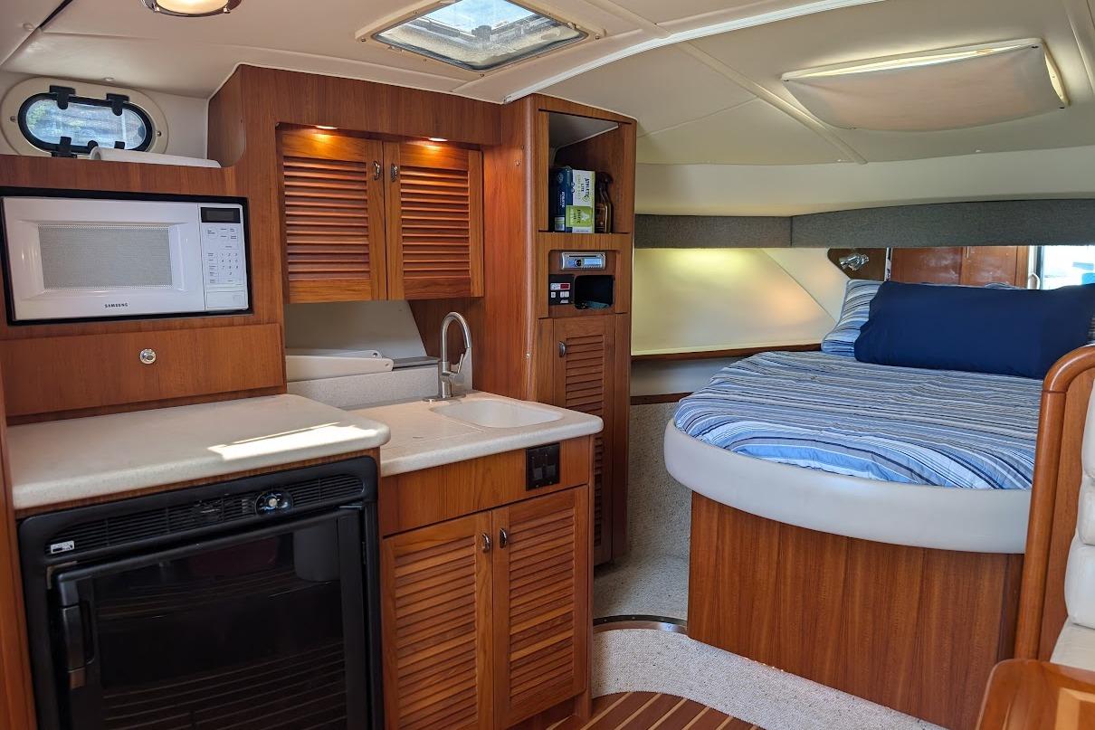 Interior of a 2000 Pursuit 3400 Express boat with kitchen and bed area.