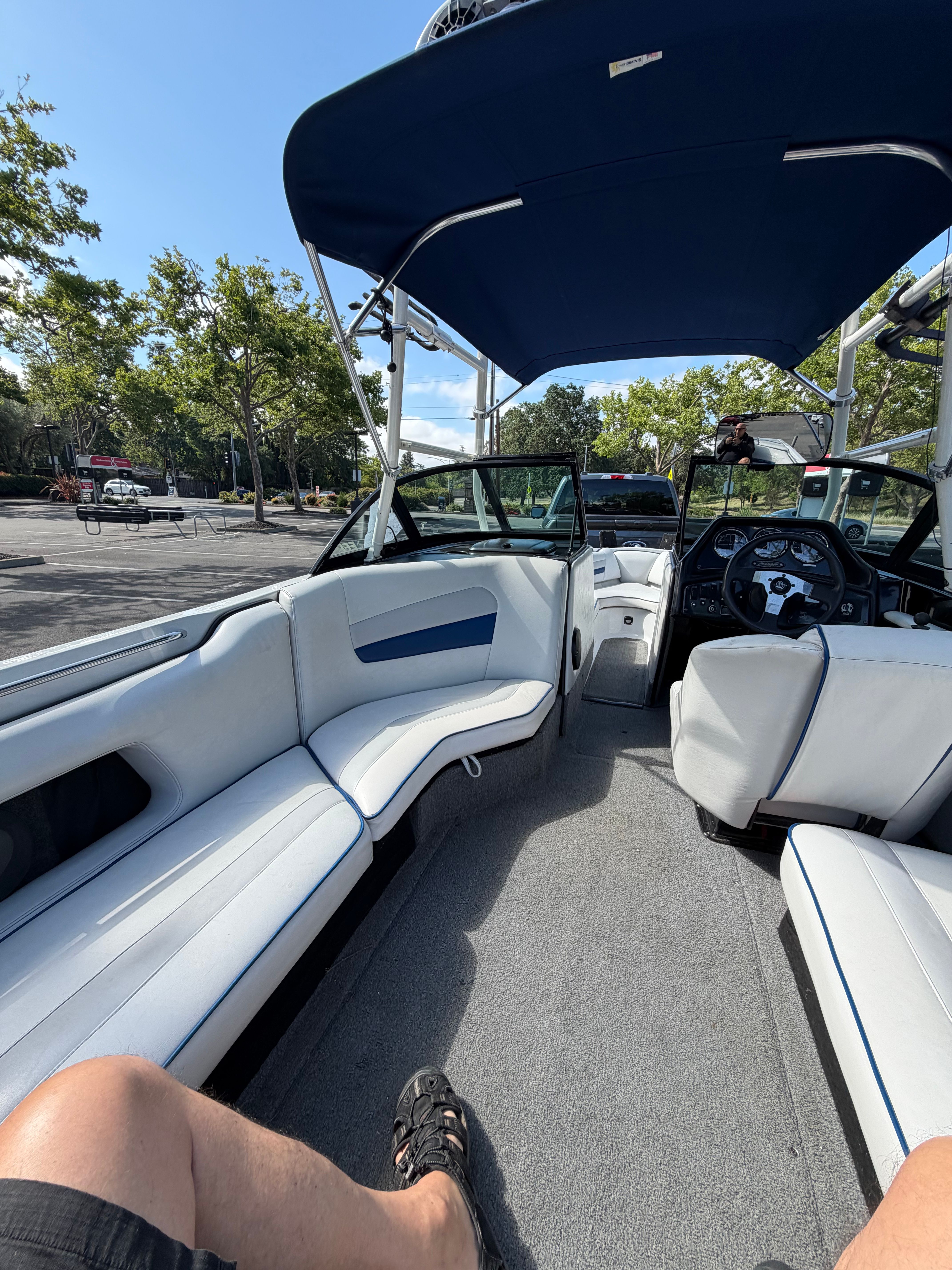 Interior view of a Sanger V210 boat with blue and white seating and a blue sunshade.