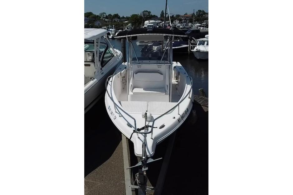2002 Pro-Line 23 Sport boat docked at a marina, featuring a sleek white design.