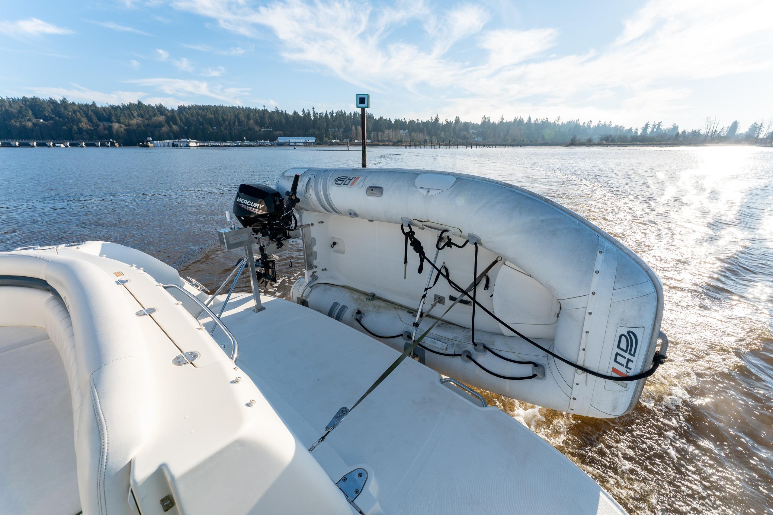 2004 Sea Ray 390 Sundancer with inflatable boat and Mercury motor on calm water.