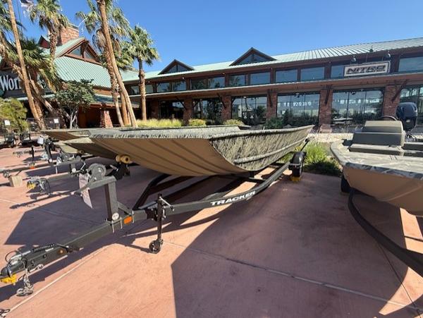 2025 Tracker GRIZZLY 2072 Utility boat on trailer outside a store.