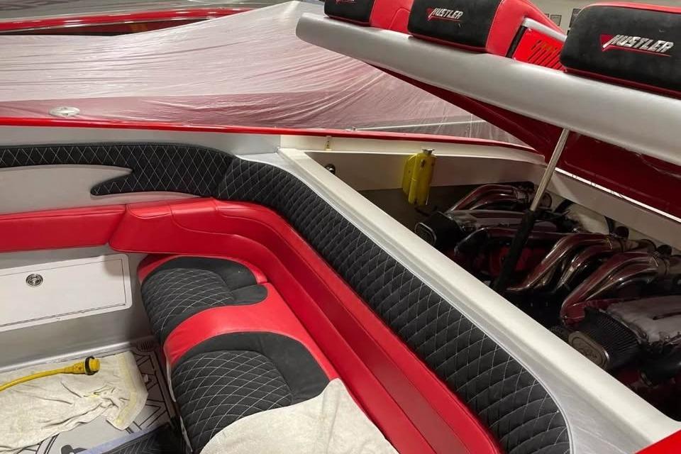 Interior of a 2005 Hustler 388 SLINGSHOT boat with red and black seating.