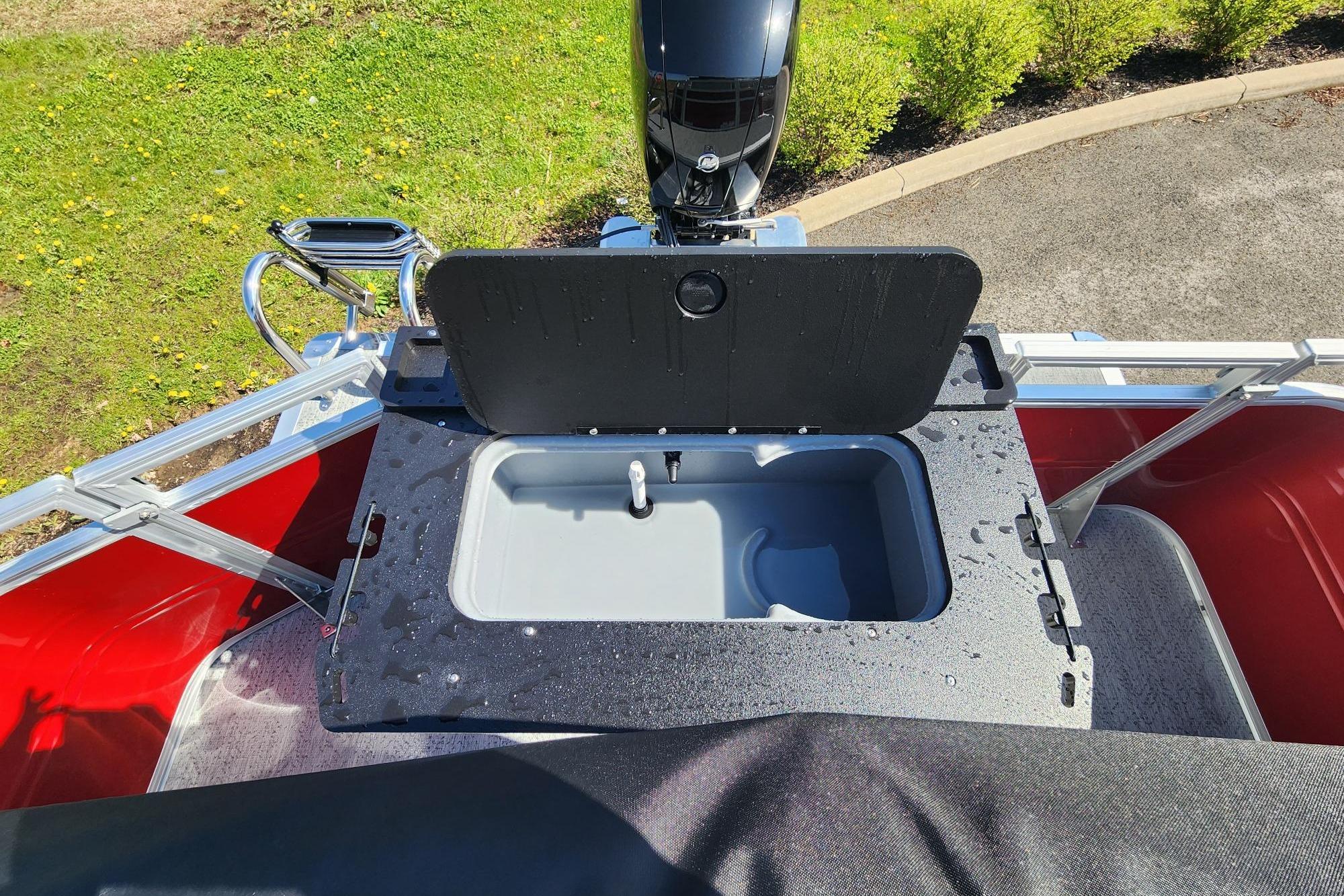 2026 Sun Tracker Fishin' Barge 22 DLX livewell with open lid, showcasing fishing amenities.