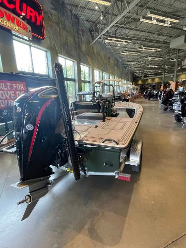 2025 Mako 18 Pro Skiff Backwater Edition displayed in a showroom with outboard motor.