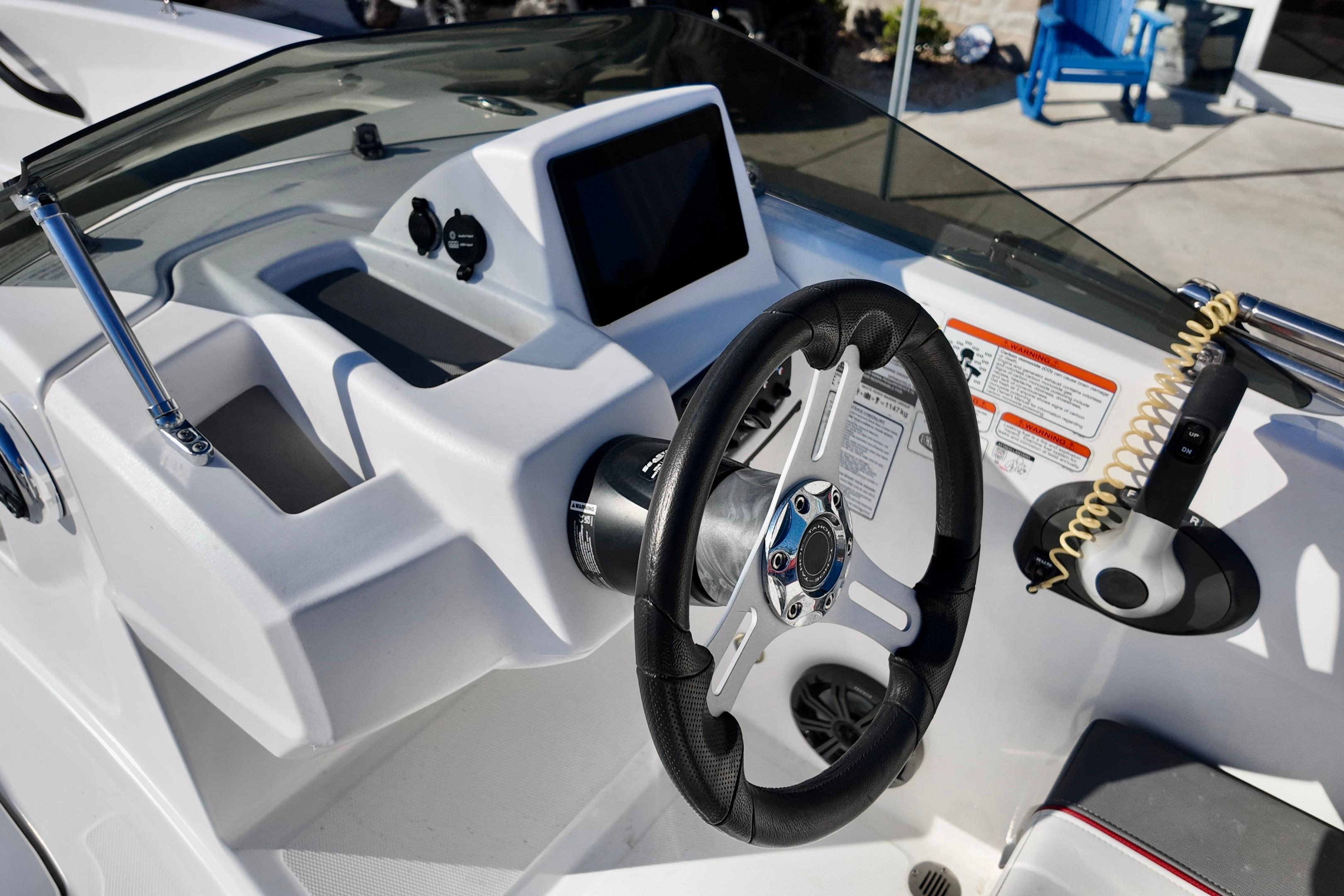 2024 Tahoe T18 boat dashboard with steering wheel and control panel.