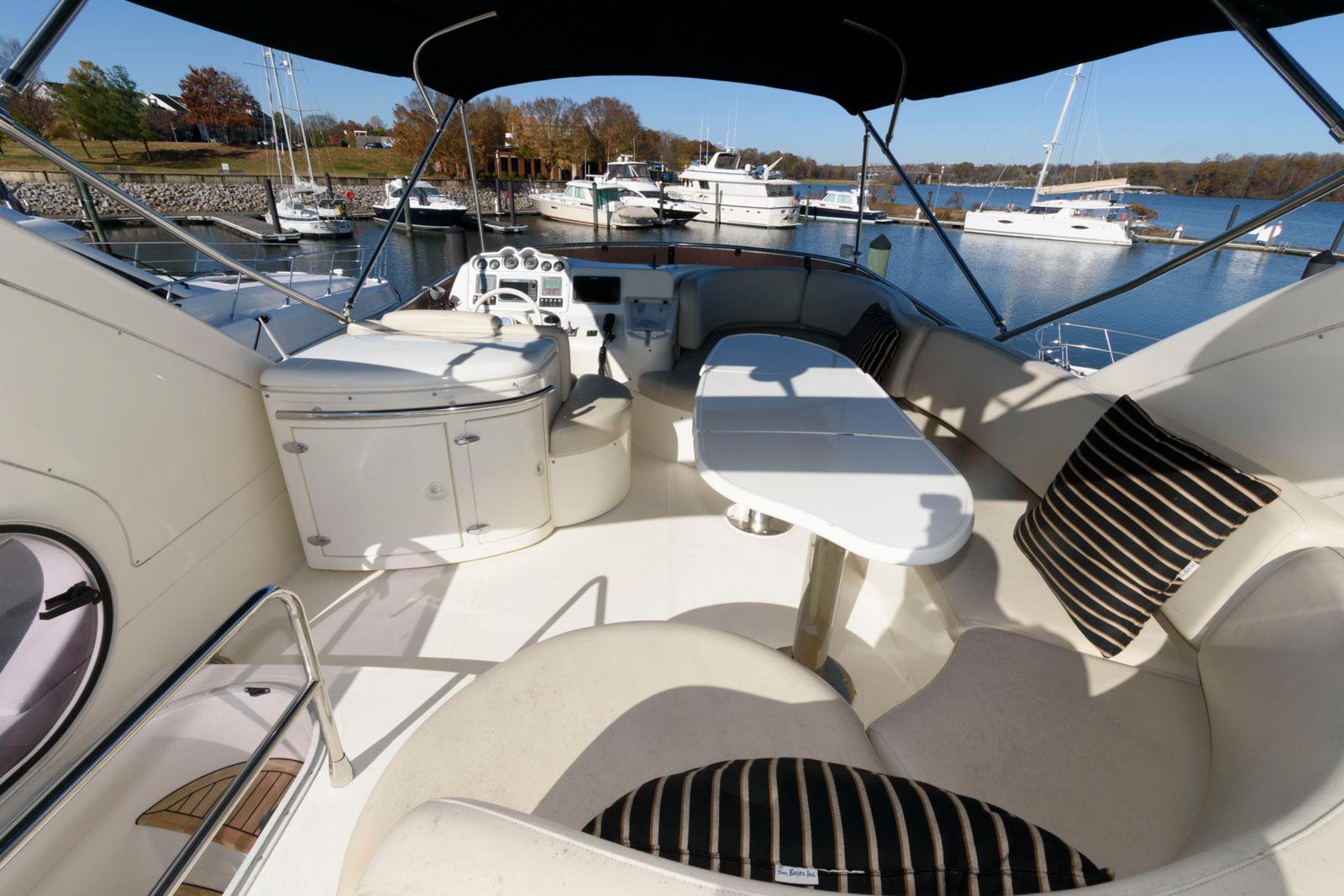 2005 Azimut 50 Flybridge yacht interior with seating and table, docked at marina.