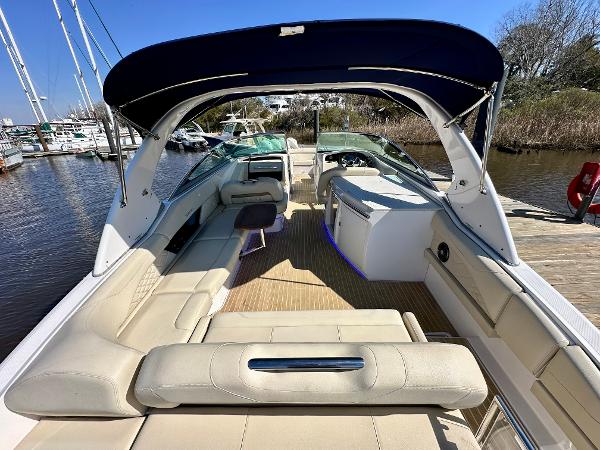 The image shows the interior of a 2018 Regal 3300 boat with beige seating and a blue canopy.