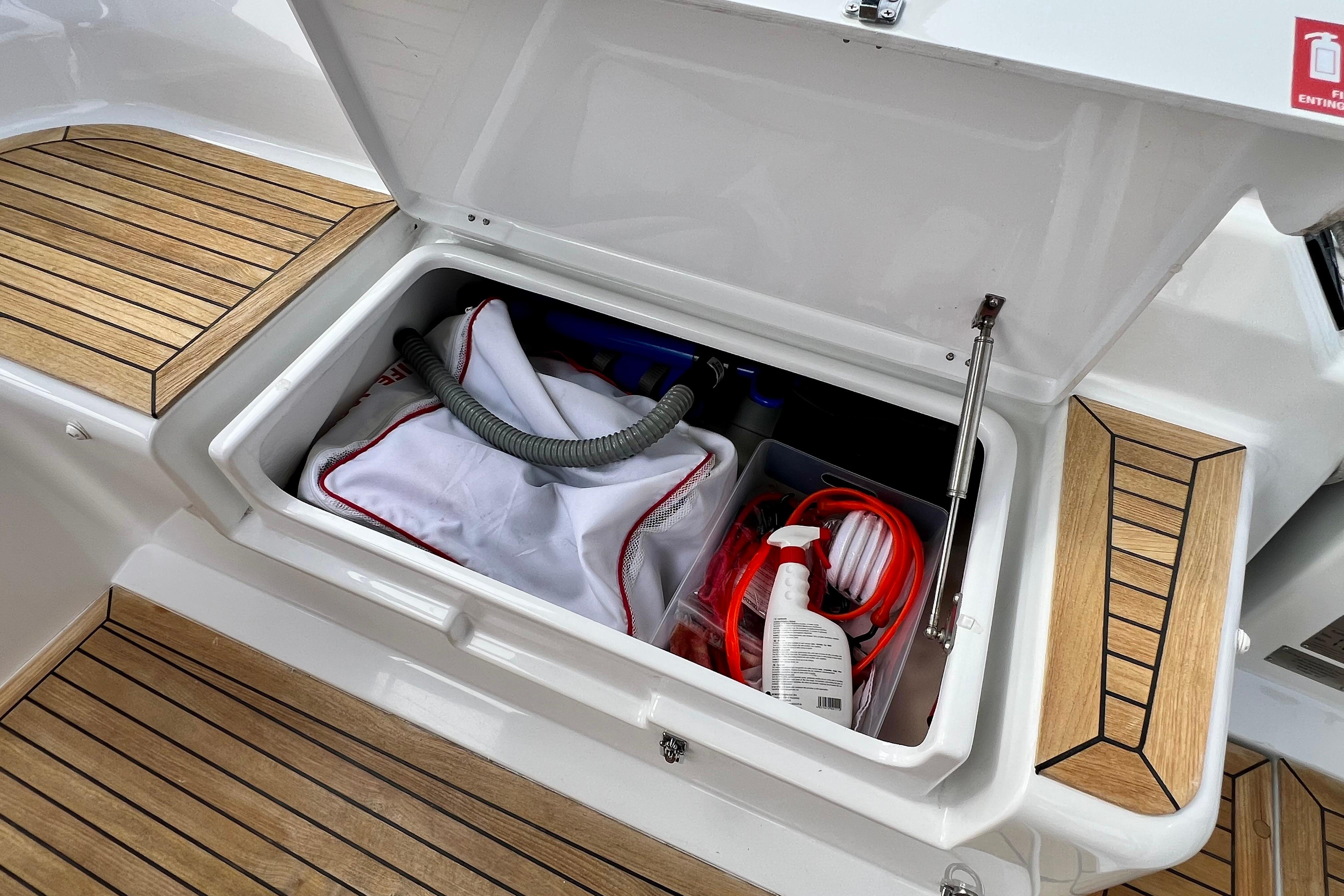 Open storage compartment on 2016 Hanse 455 yacht with cleaning supplies and equipment.