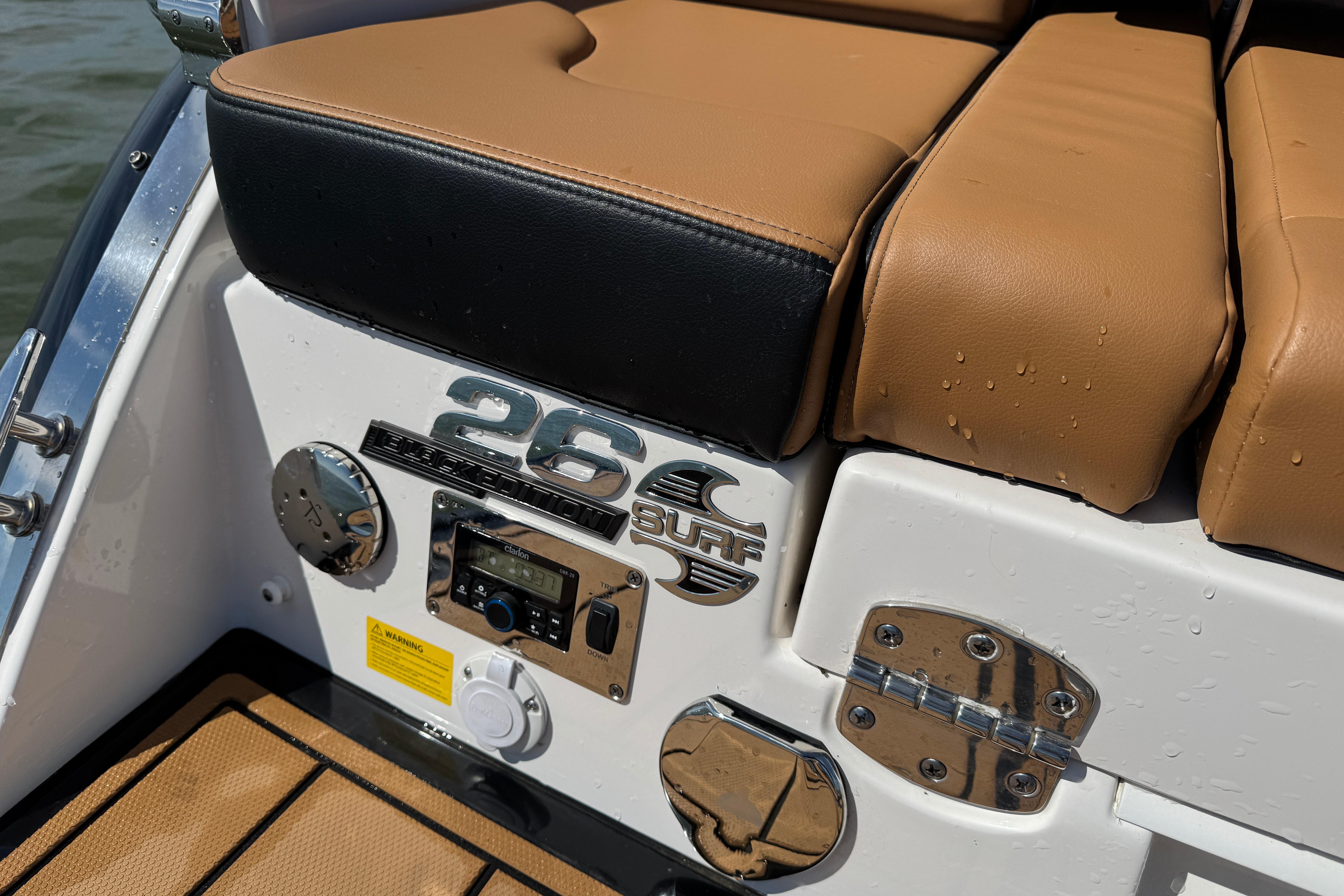 2023 Chaparral 26 Surf boat interior with tan seating and control panel.