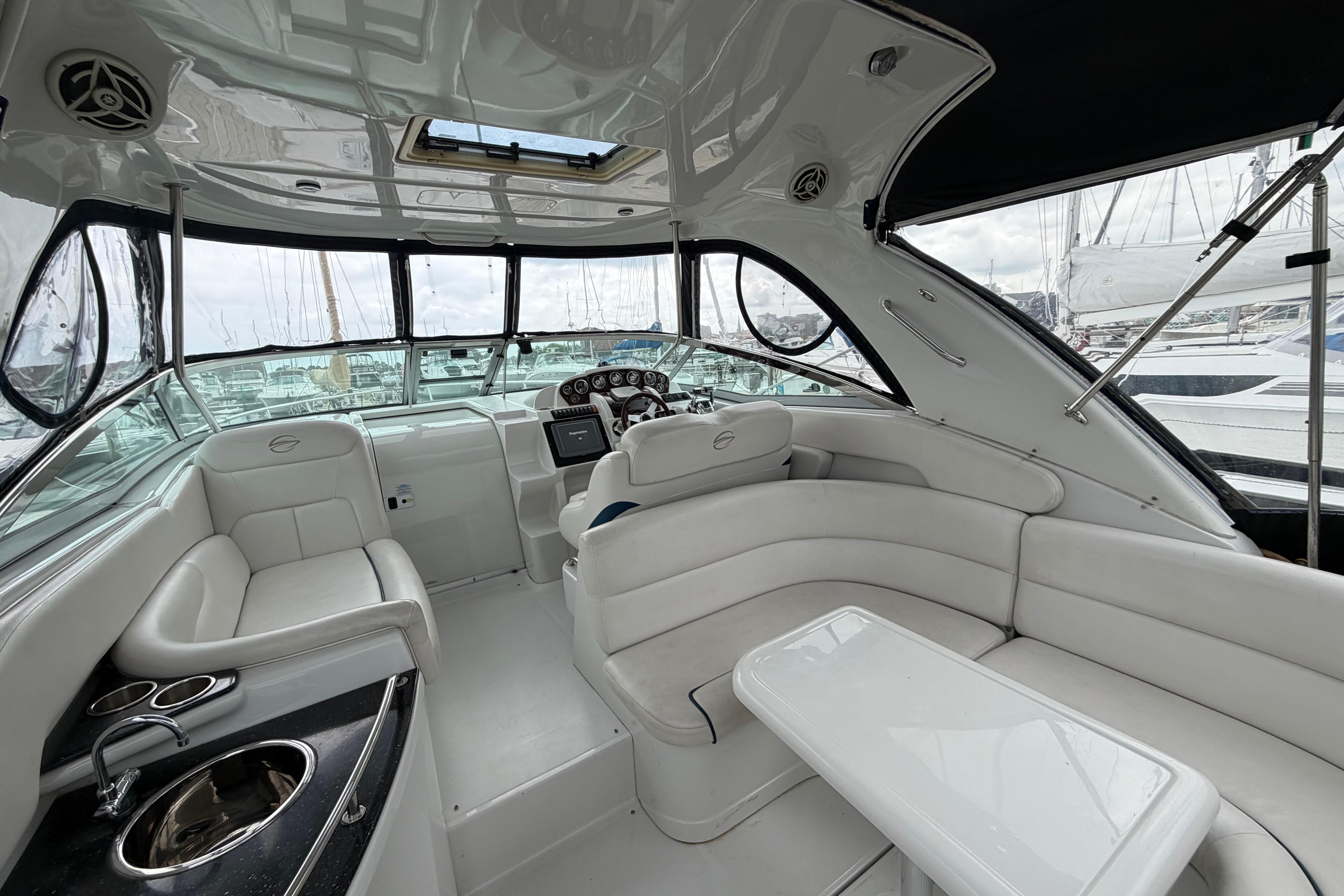 Luxurious interior of 2008 Crownline 340 CR yacht with white seating and helm.