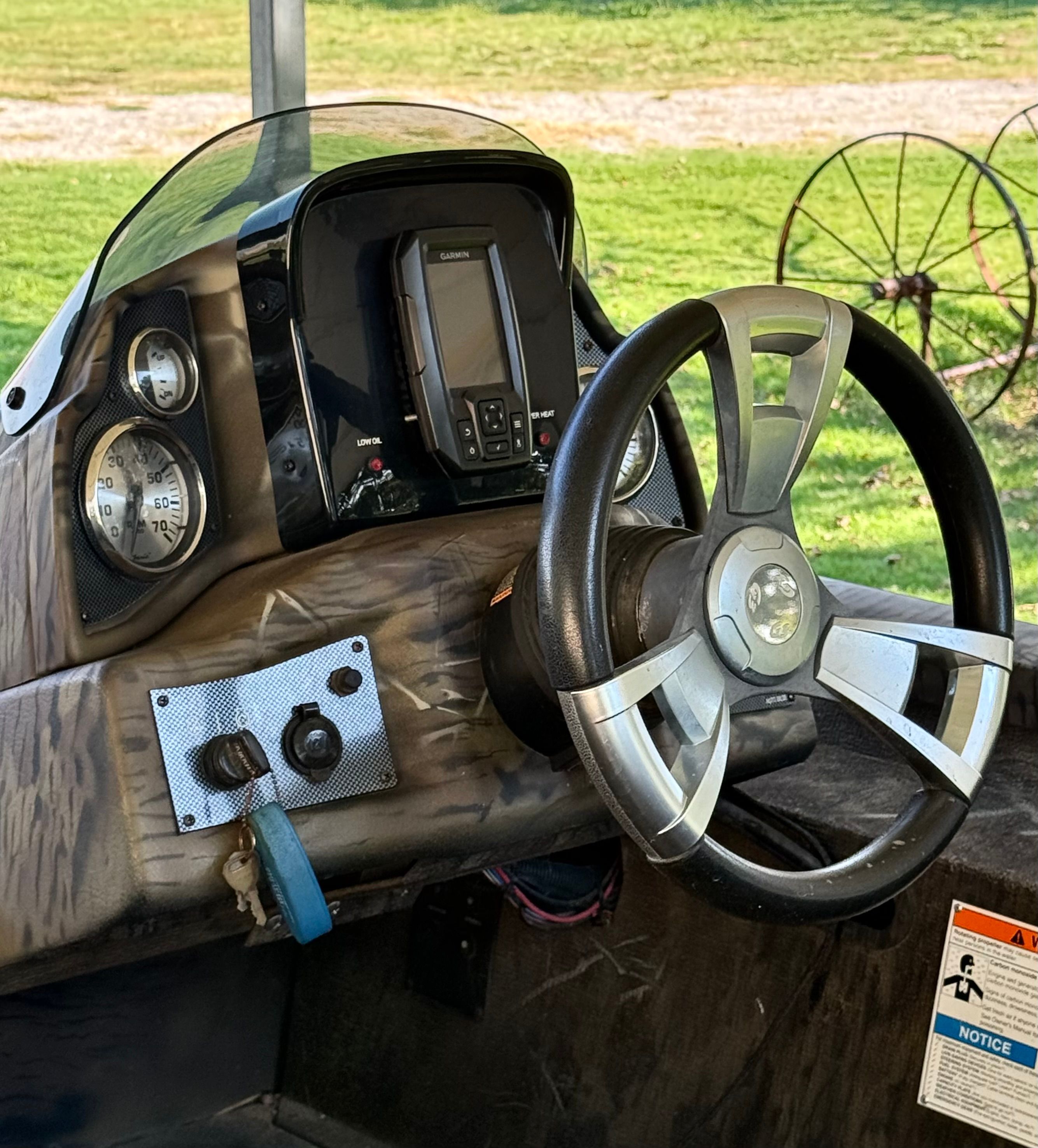 The image shows the cockpit of a 2017 G3 Sportsman 17 Camo boat with a steering wheel and instruments.