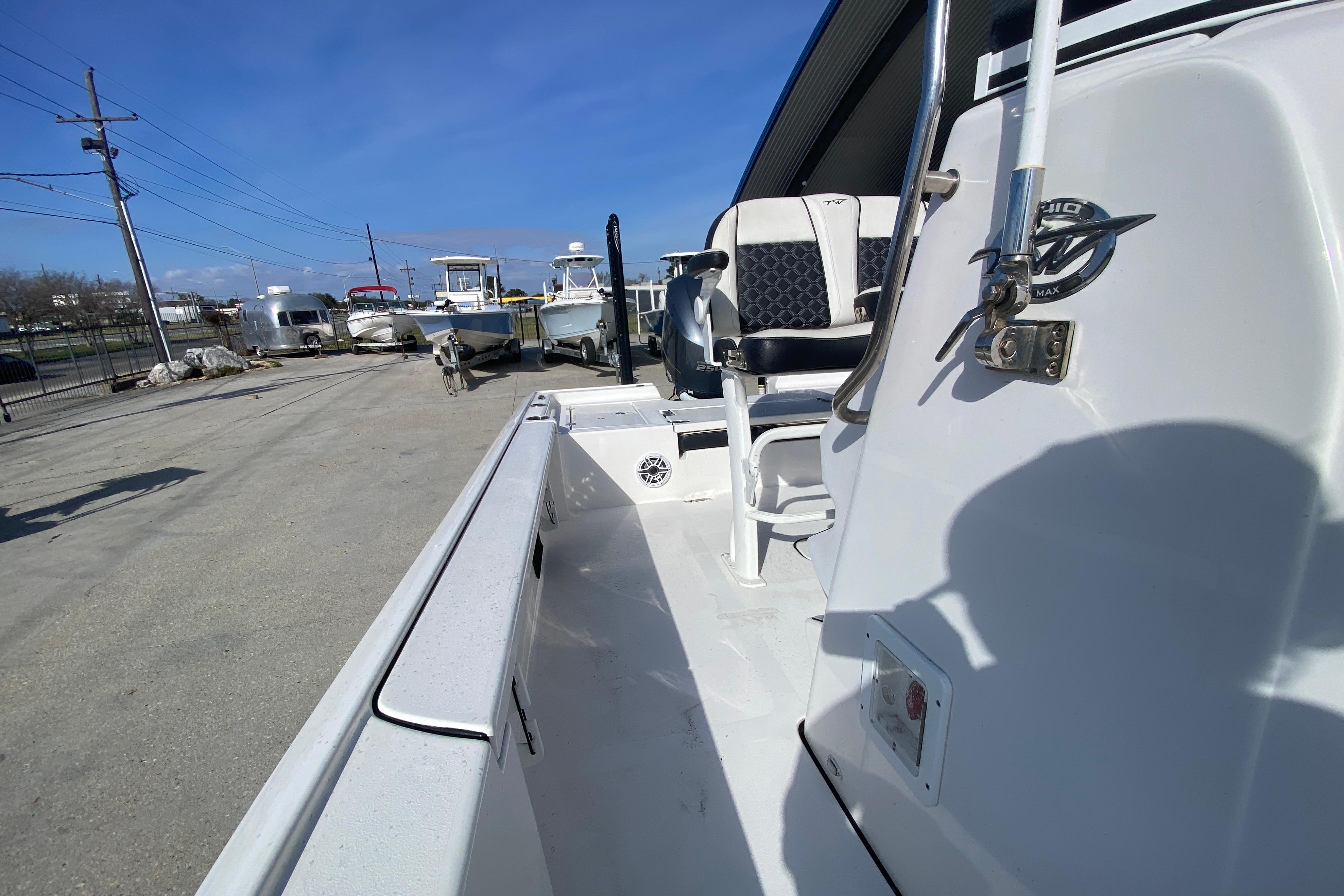 2023 Tidewater 2410 Bay Max boat interior with seating, parked outdoors under clear sky.