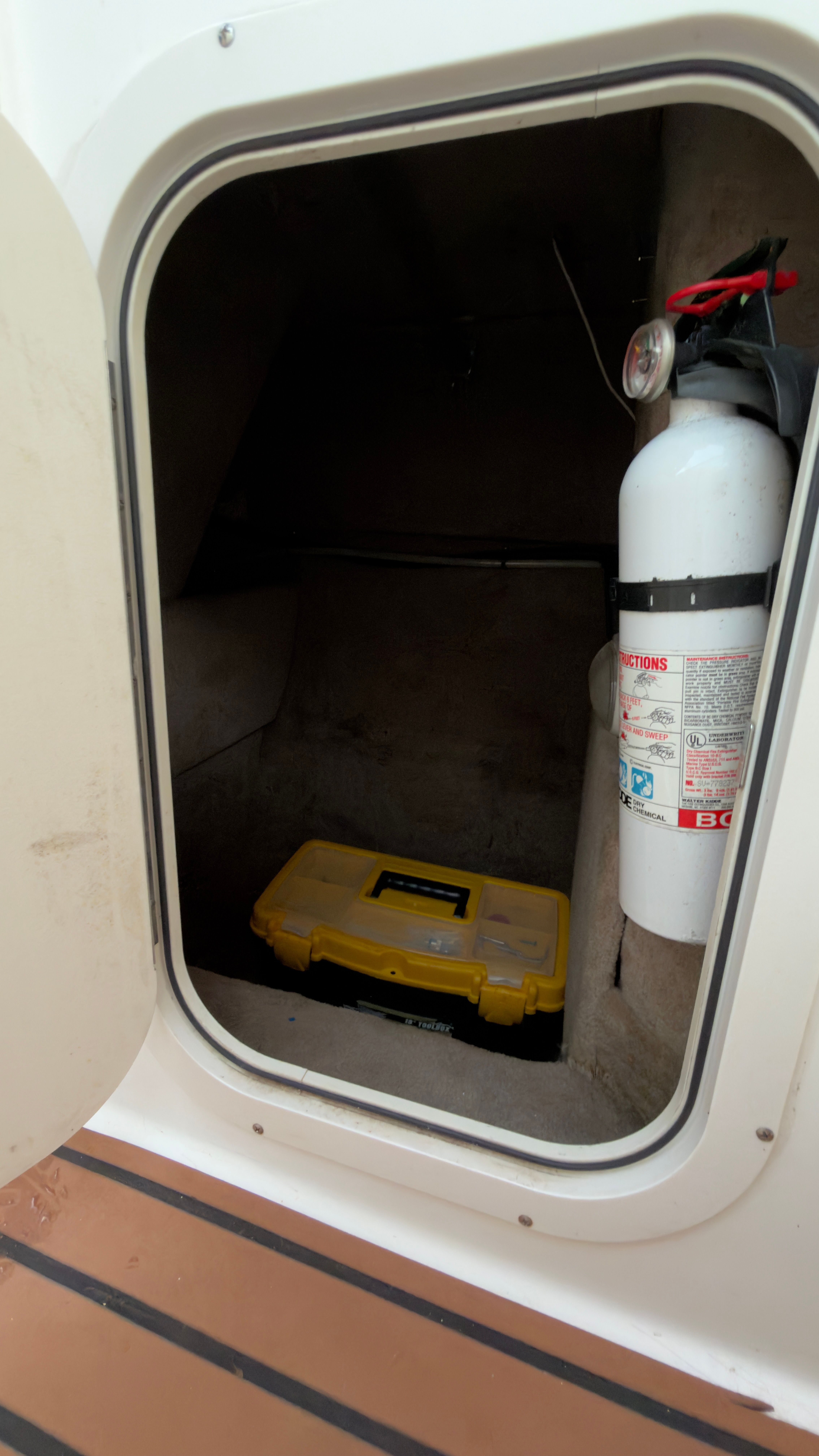 Storage compartment in Chaparral 263 Sunesta Deckboat with fire extinguisher.