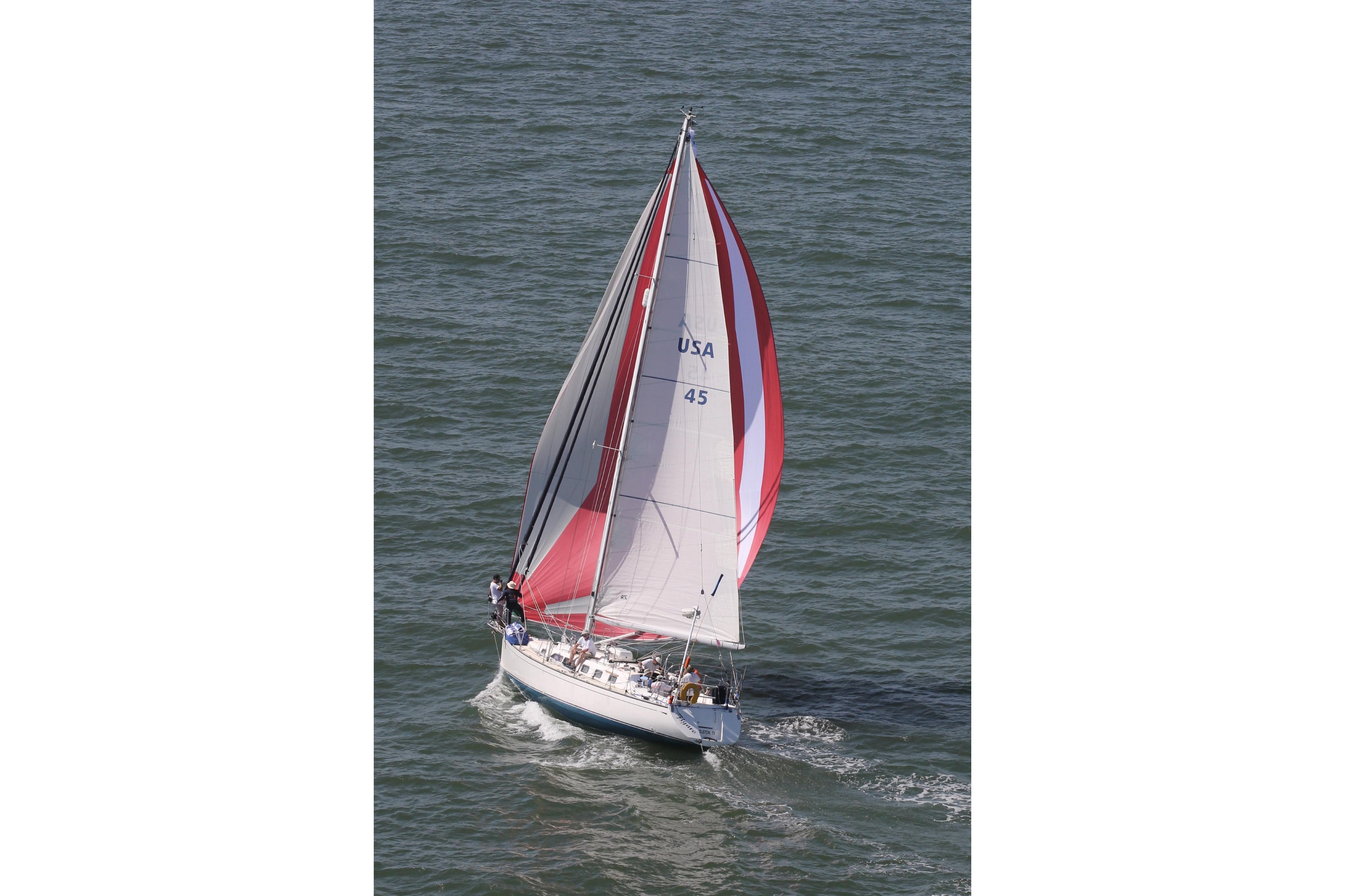 Sailing yacht Saga 43 (2002) with red and white sails on open water.