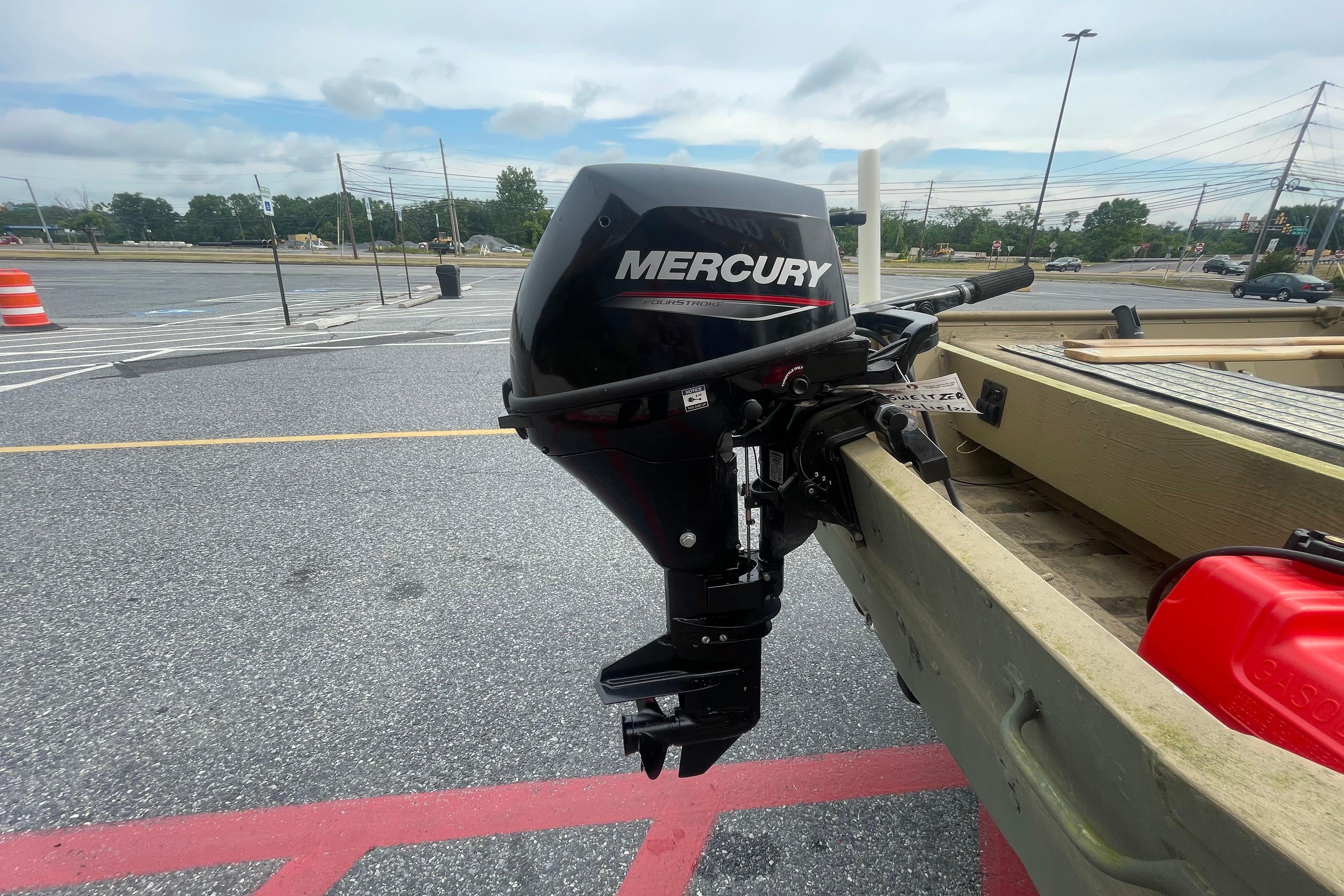 1986 Landau 1664 Jon boat with Mercury outboard motor in parking lot.