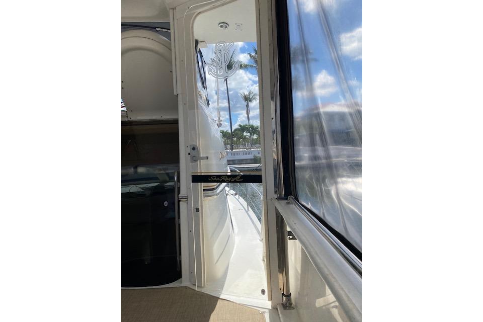 1997 Sea Ray 370 Aft Cabin yacht interior with glass door and scenic view.