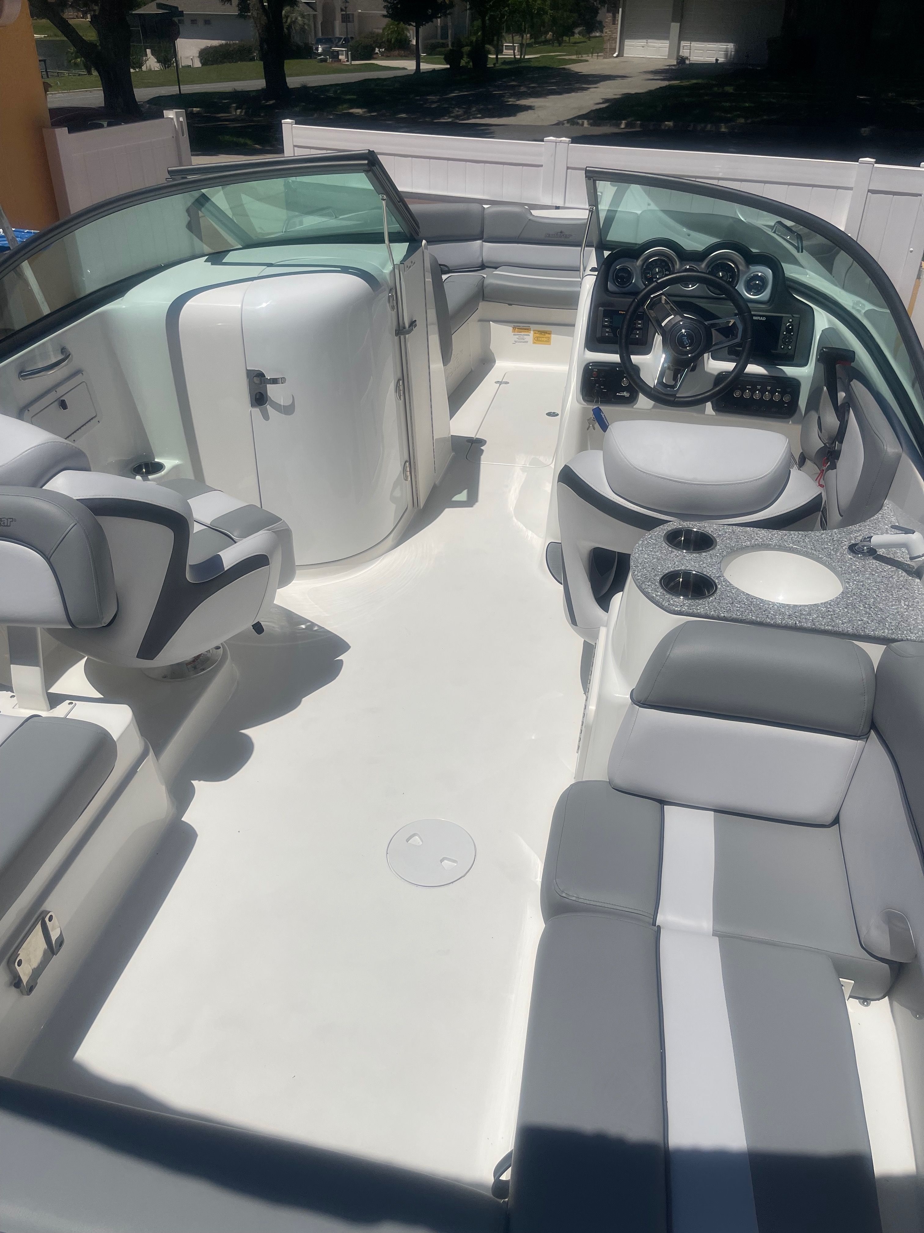 The image shows the interior of a 2022 NauticStar 243 DC boat with gray and white seating.