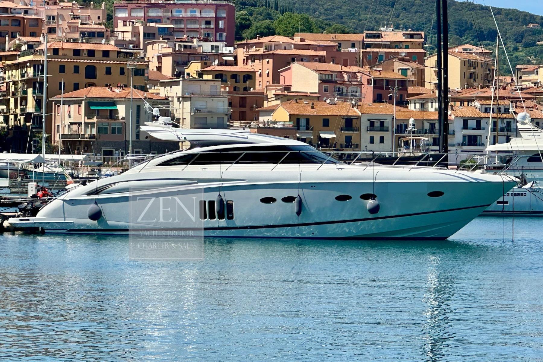 2009 Princess V62 yacht docked in a scenic marina with colorful buildings.