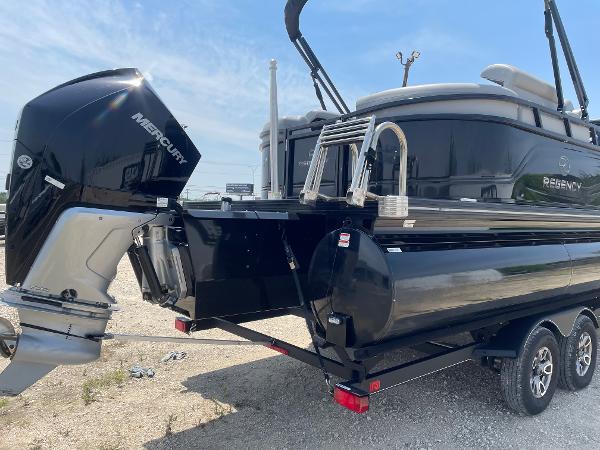 2023 Regency 250 LE3 pontoon boat with Mercury outboard engine, parked on a trailer.