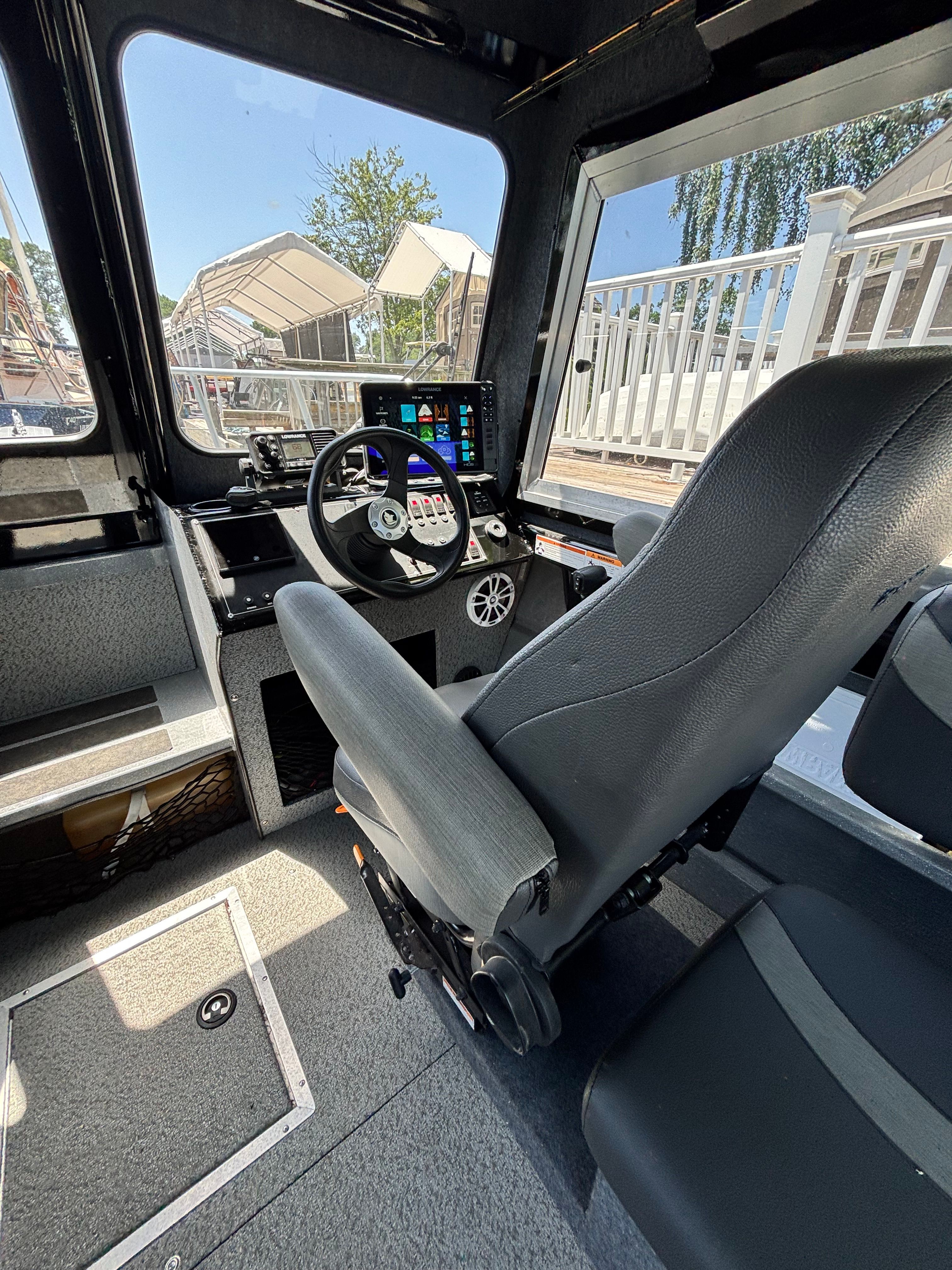 Interior of a 2021 Spartan 240 Maximus with a modern helm and gray seating.