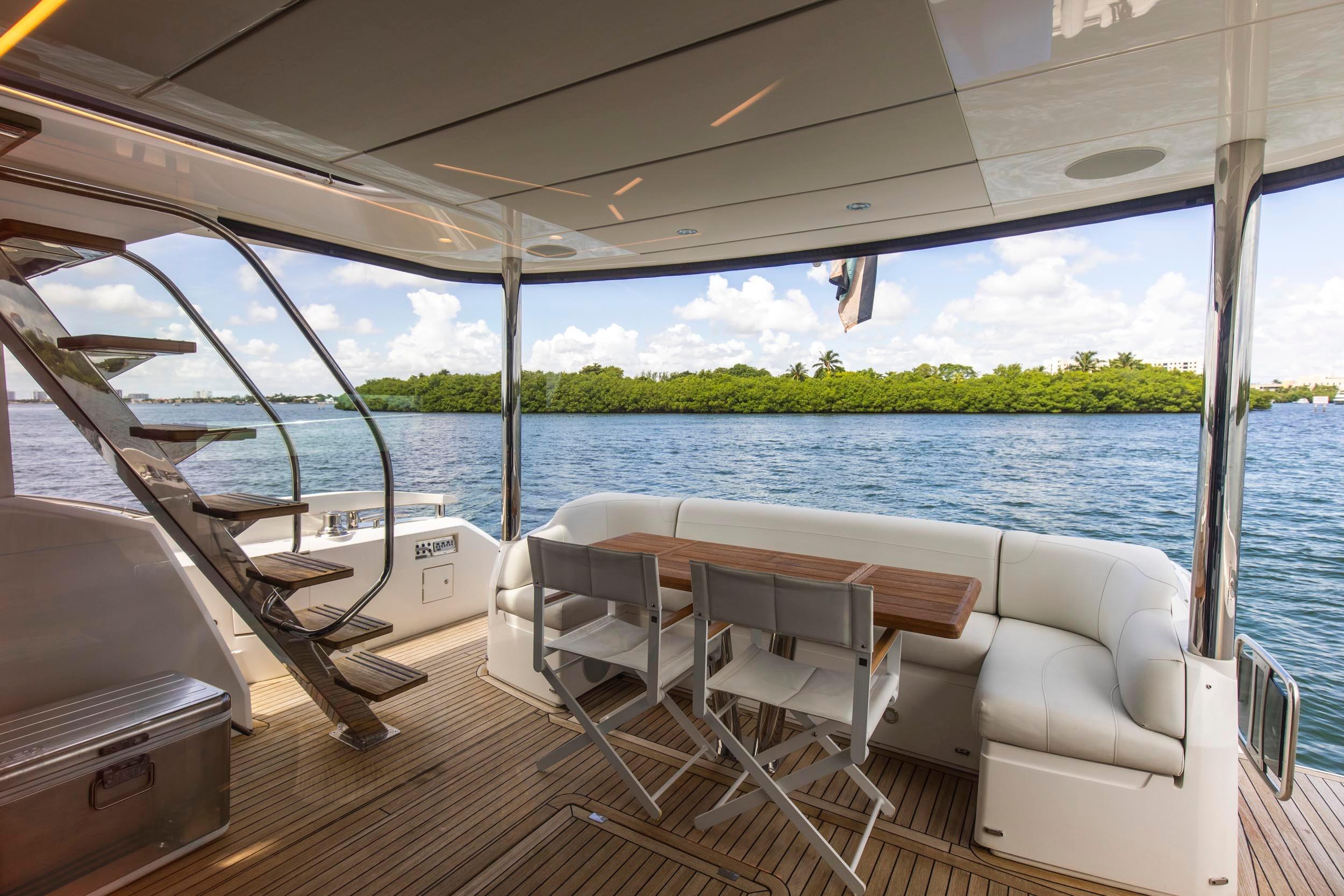 Luxurious 2021 Sunseeker Manhattan 68 yacht deck with seating, table, and ocean view.