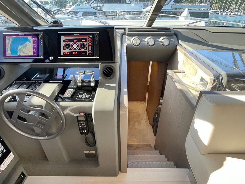 Control panel of a 2018 Ferretti Yachts 550, featuring navigation screens and steering wheel.