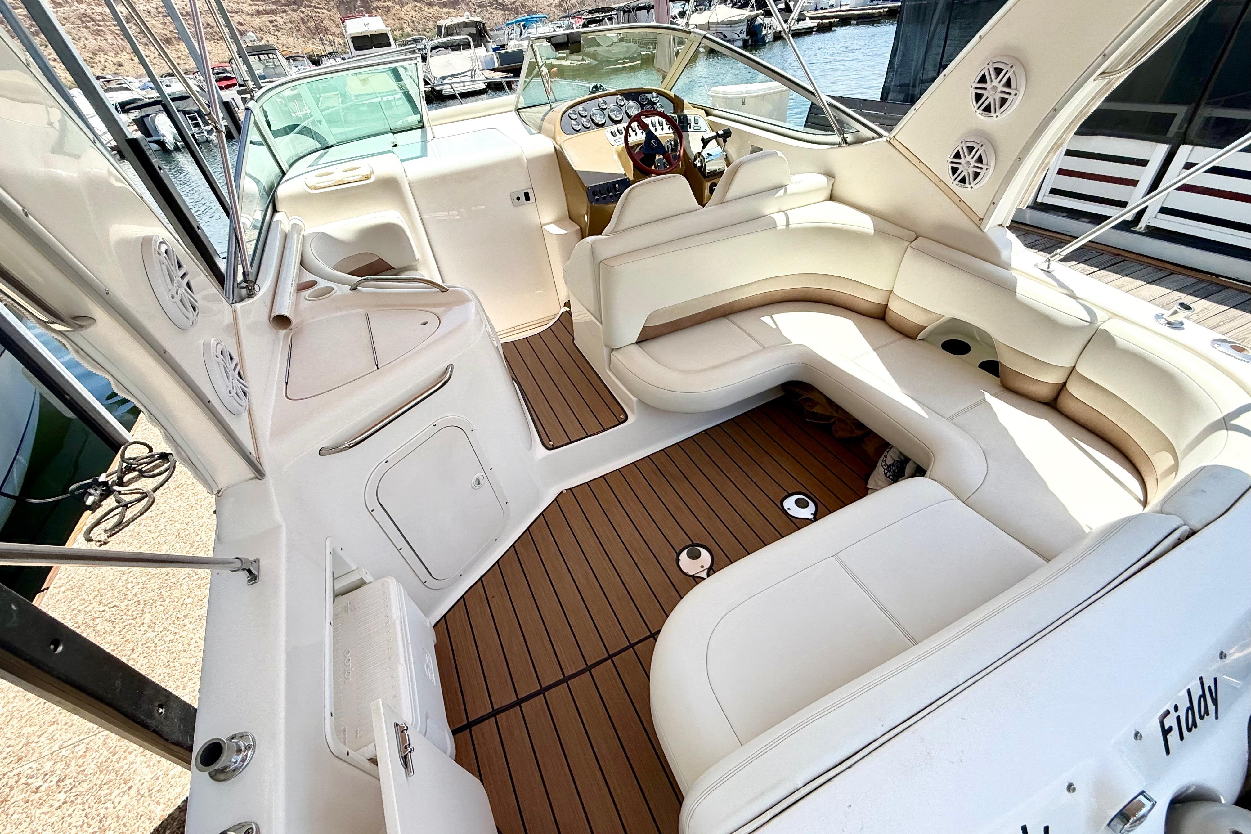 1999 Chaparral Signature 300 boat interior with white seating and wood flooring at a marina.