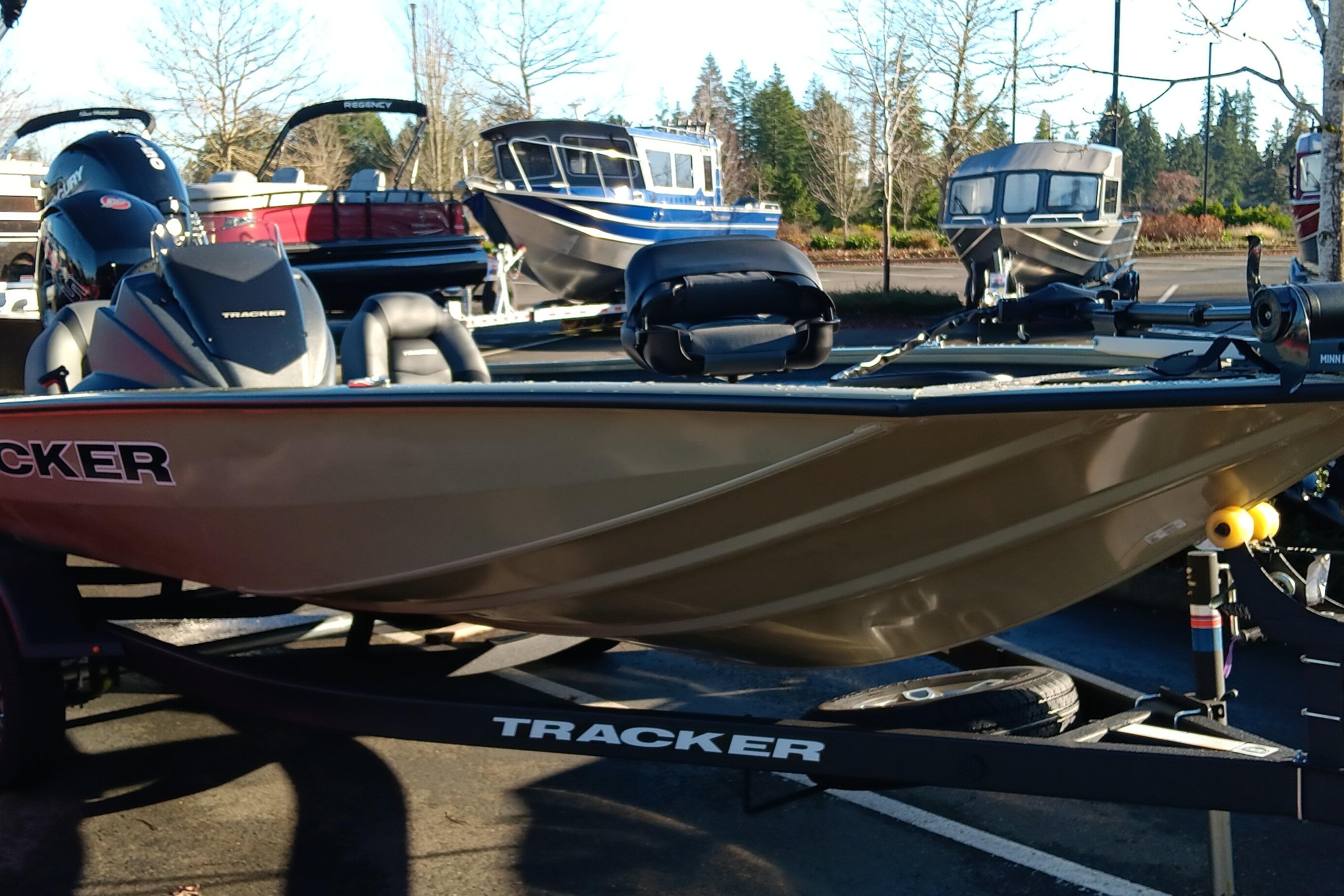 2026 Tracker Pro Team 195 boat on trailer, parked outdoors with other boats.