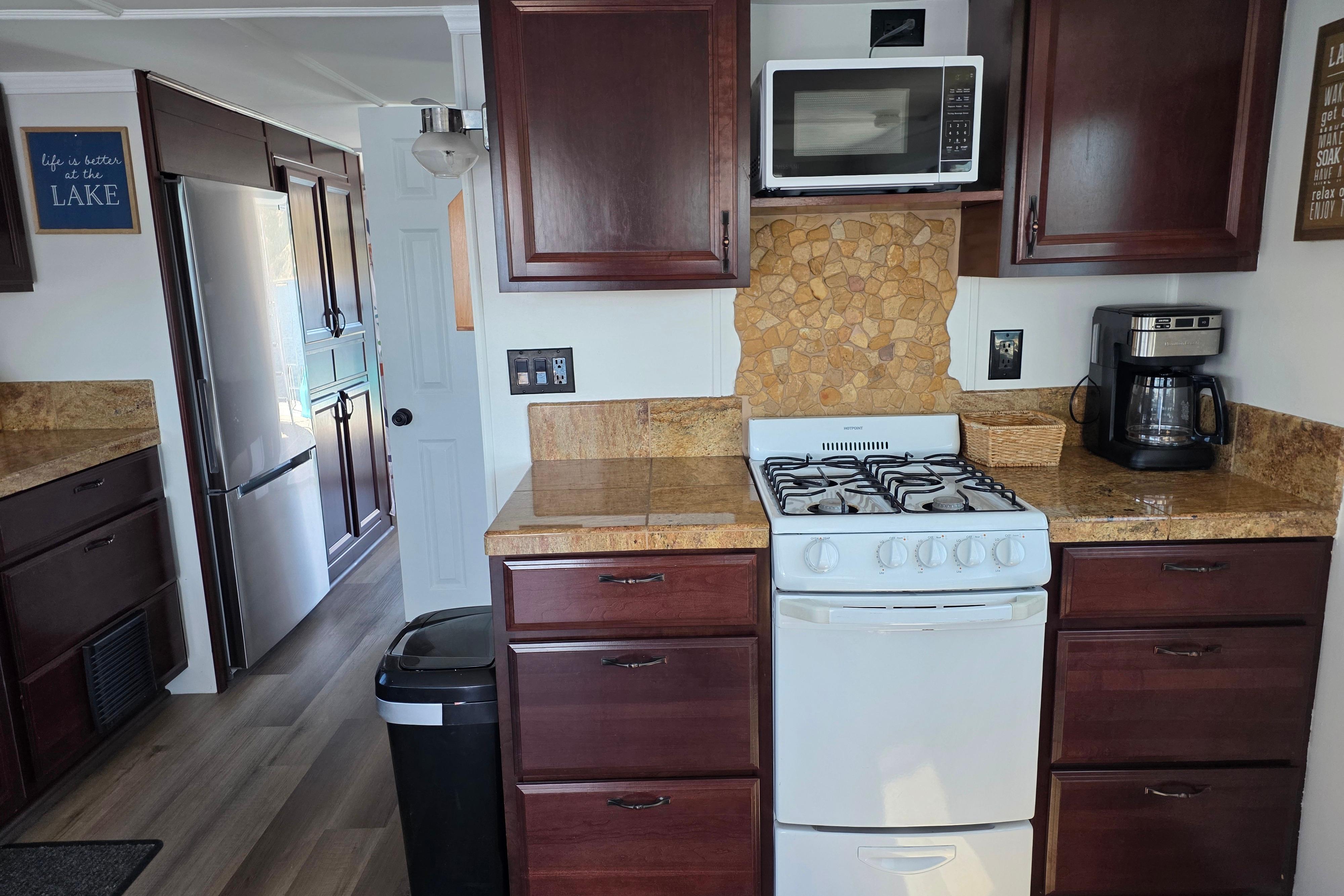 Houseboat kitchen interior with wooden cabinets, stove, microwave, and coffee maker, 2007 model.